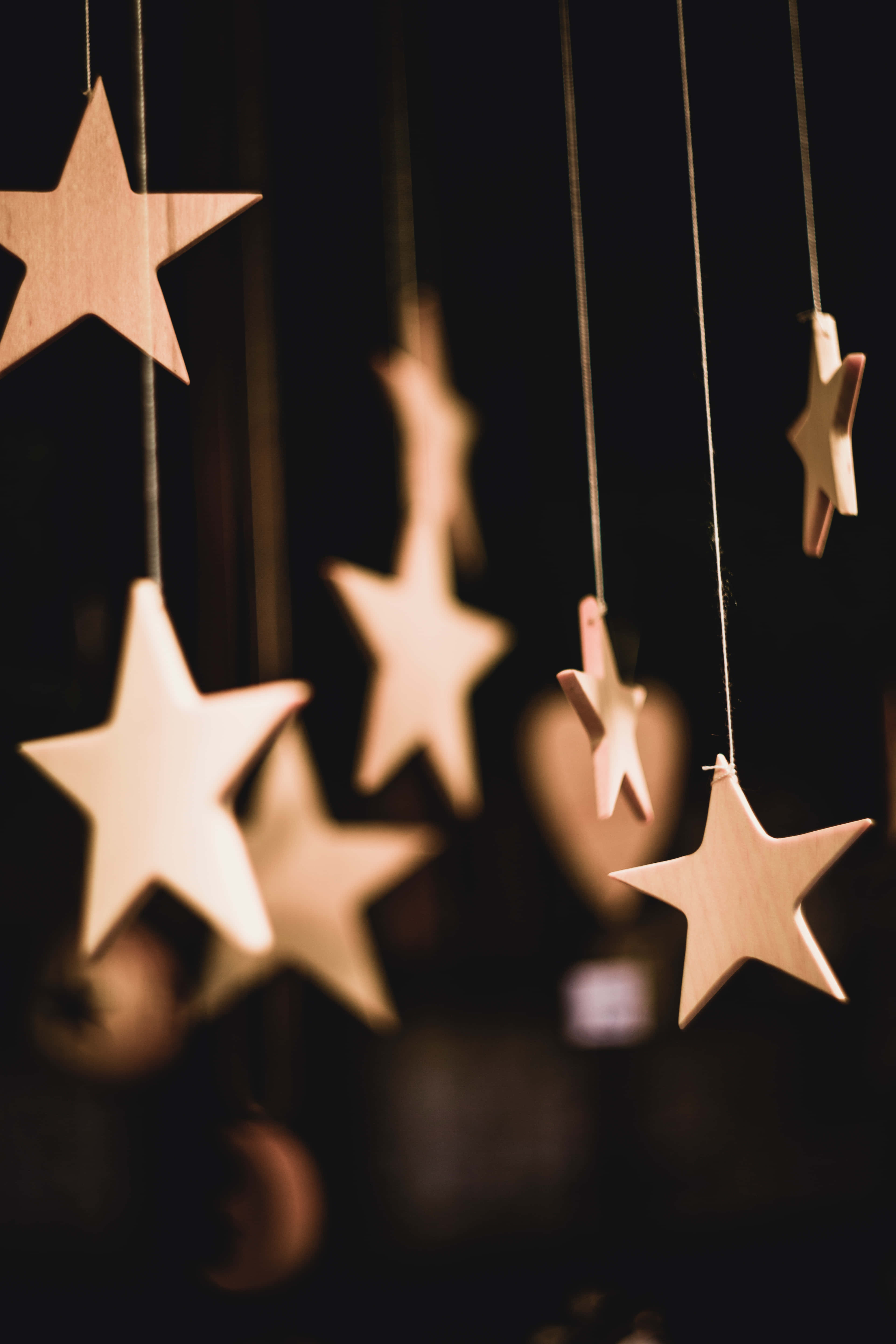 Stars 桌布 壁紙 — 溫暖的木星星掛在昏暗的燈光中，營造出舒適的節日氣氛。