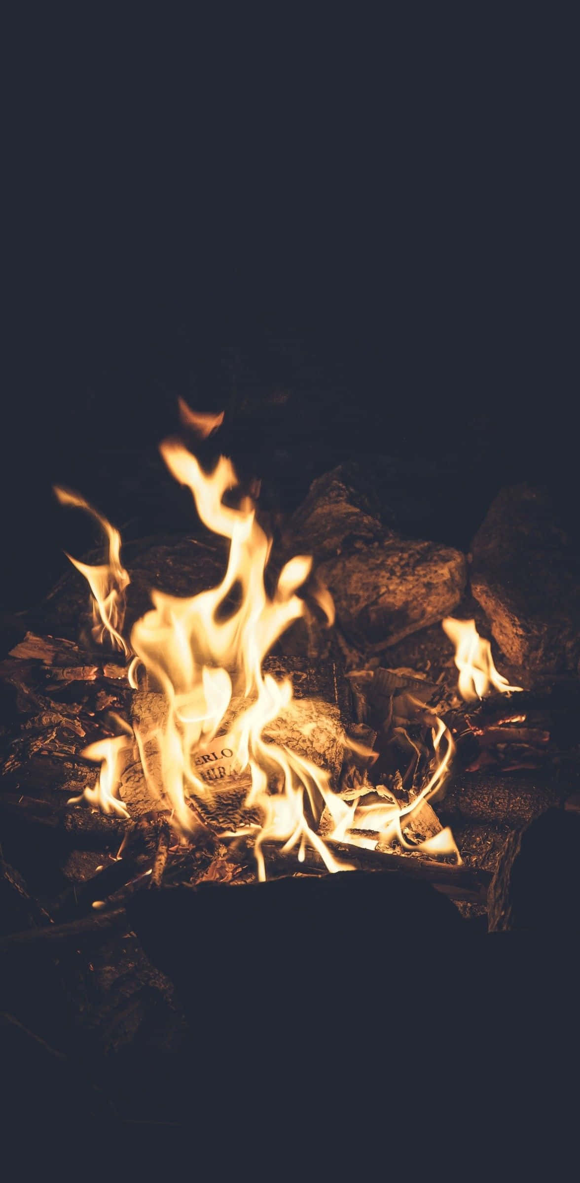 火焰動畫 桌布 壁紙 — 溫暖的營火在岩石環繞的黑暗夜空下噼啪作響，金色火焰跳動。