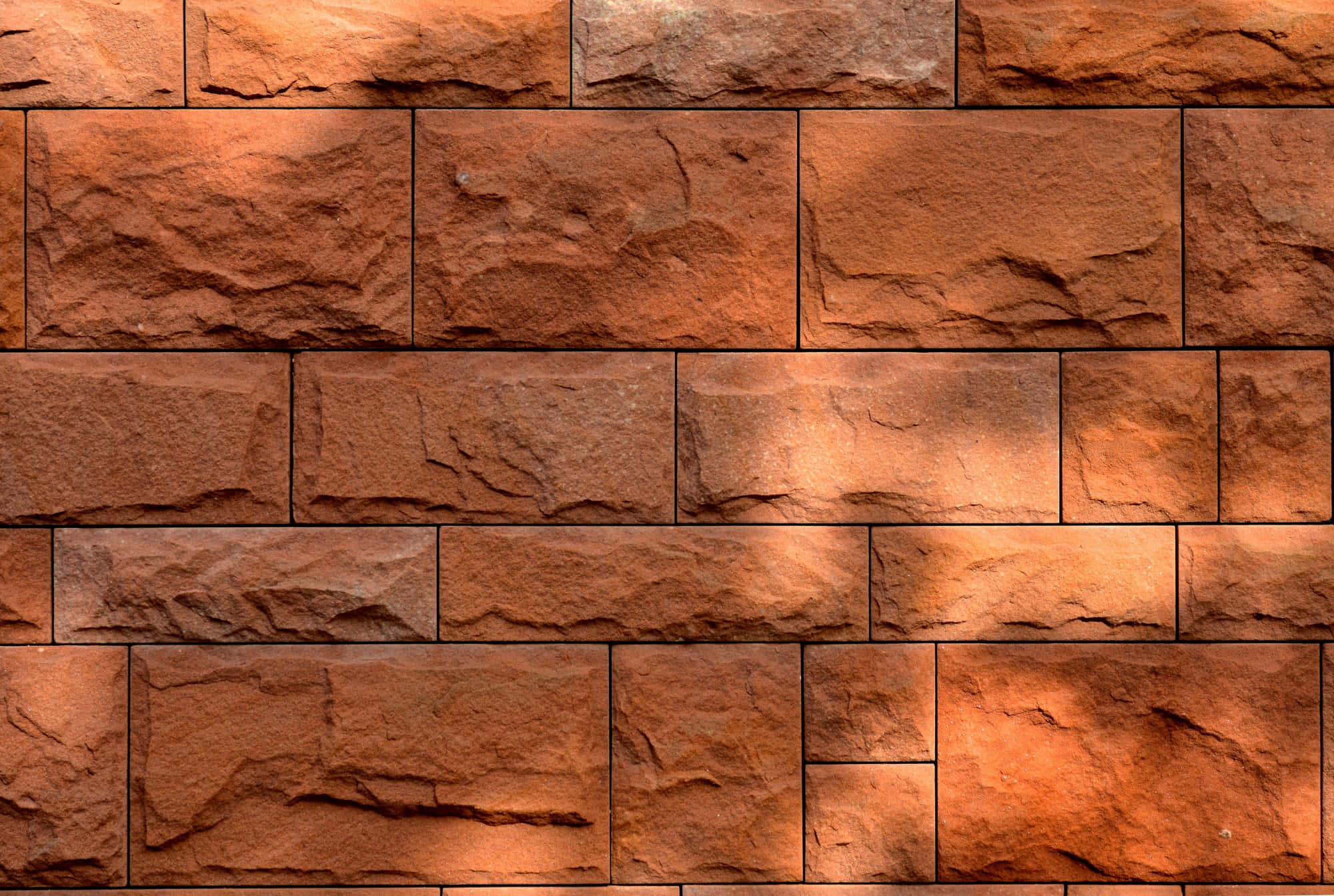 Brick 桌布 壁紙 — 溫暖的赤陶石牆，粗糙紋理的磚塊在柔和金色光線下以交錯排列方式鋪設。