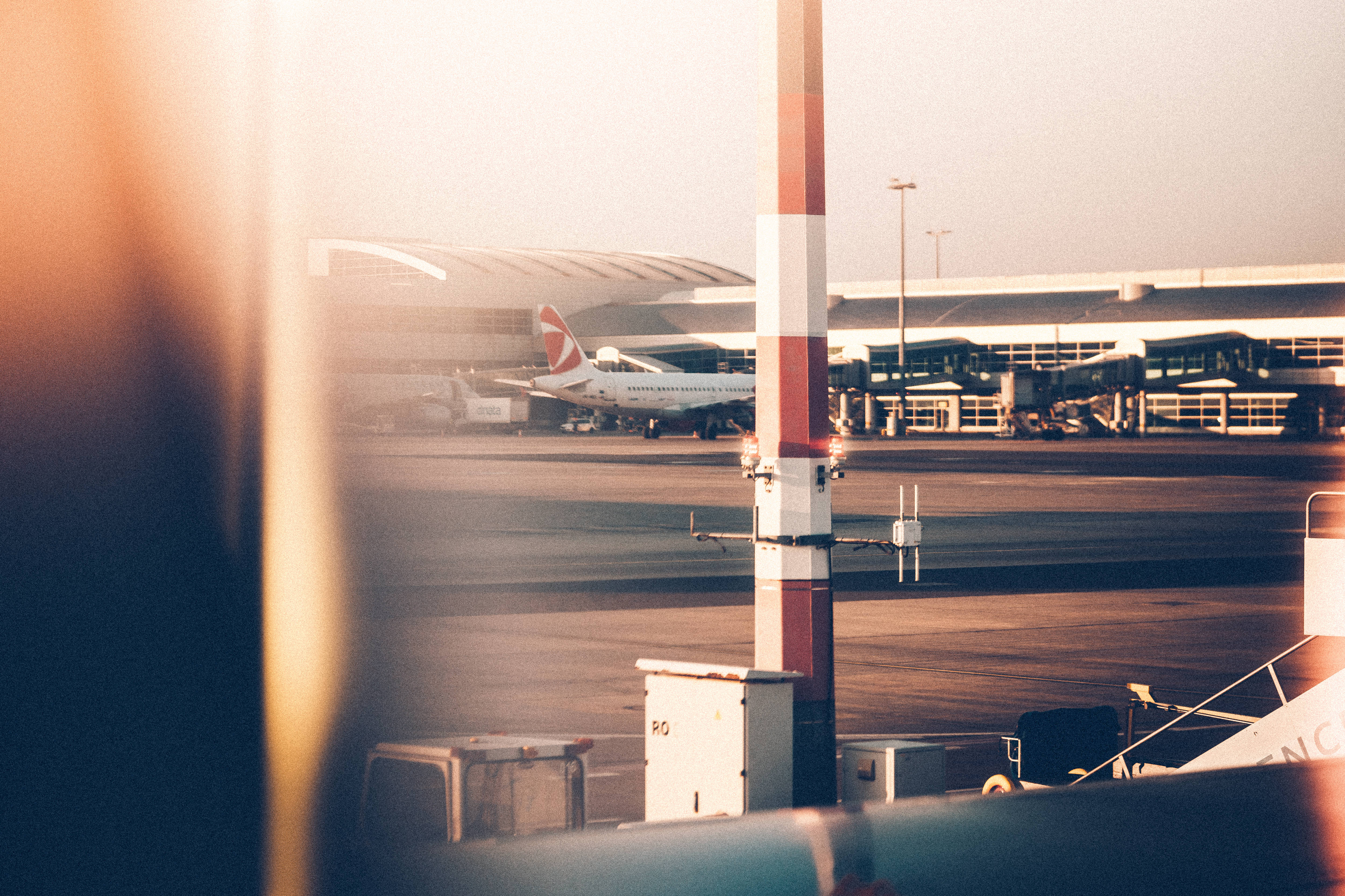復古90年代風格 桌布 壁紙 — 溫暖的金色夕陽灑在機場停機坪上，一架英國航空的飛機停在航廈閘口和條紋柱附近。