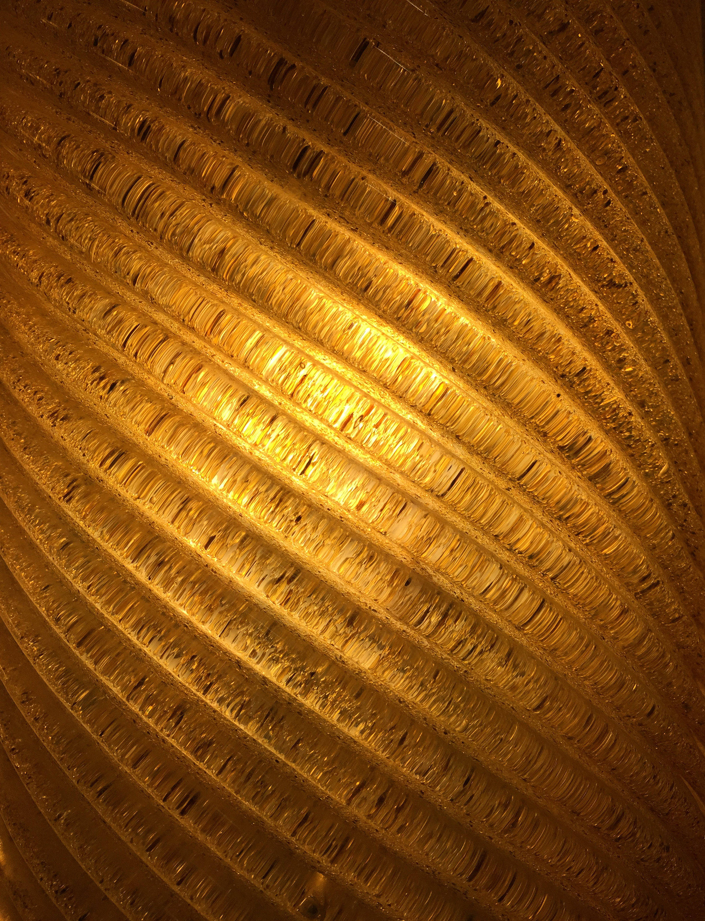 Gold Texture 桌布 壁紙 — 溫暖金色光線透過紋理棱紋玻璃的近距離特寫，形成燦爛發光圖案。