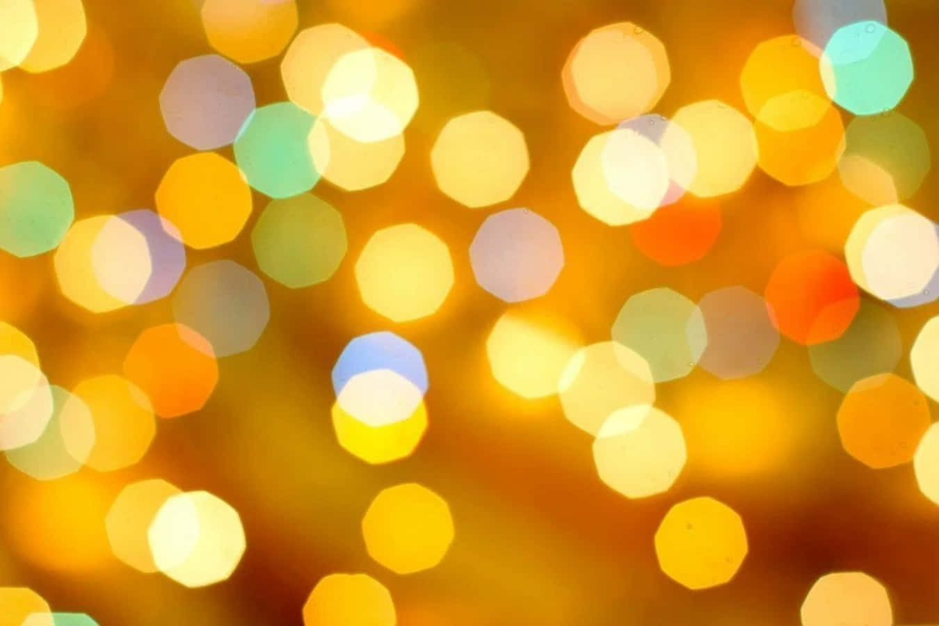 Bright 桌布 壁紙 — 溫暖金色燈光與散落的彩色六邊形模糊效果，營造出節日般閃耀的鮮豔散景背景。