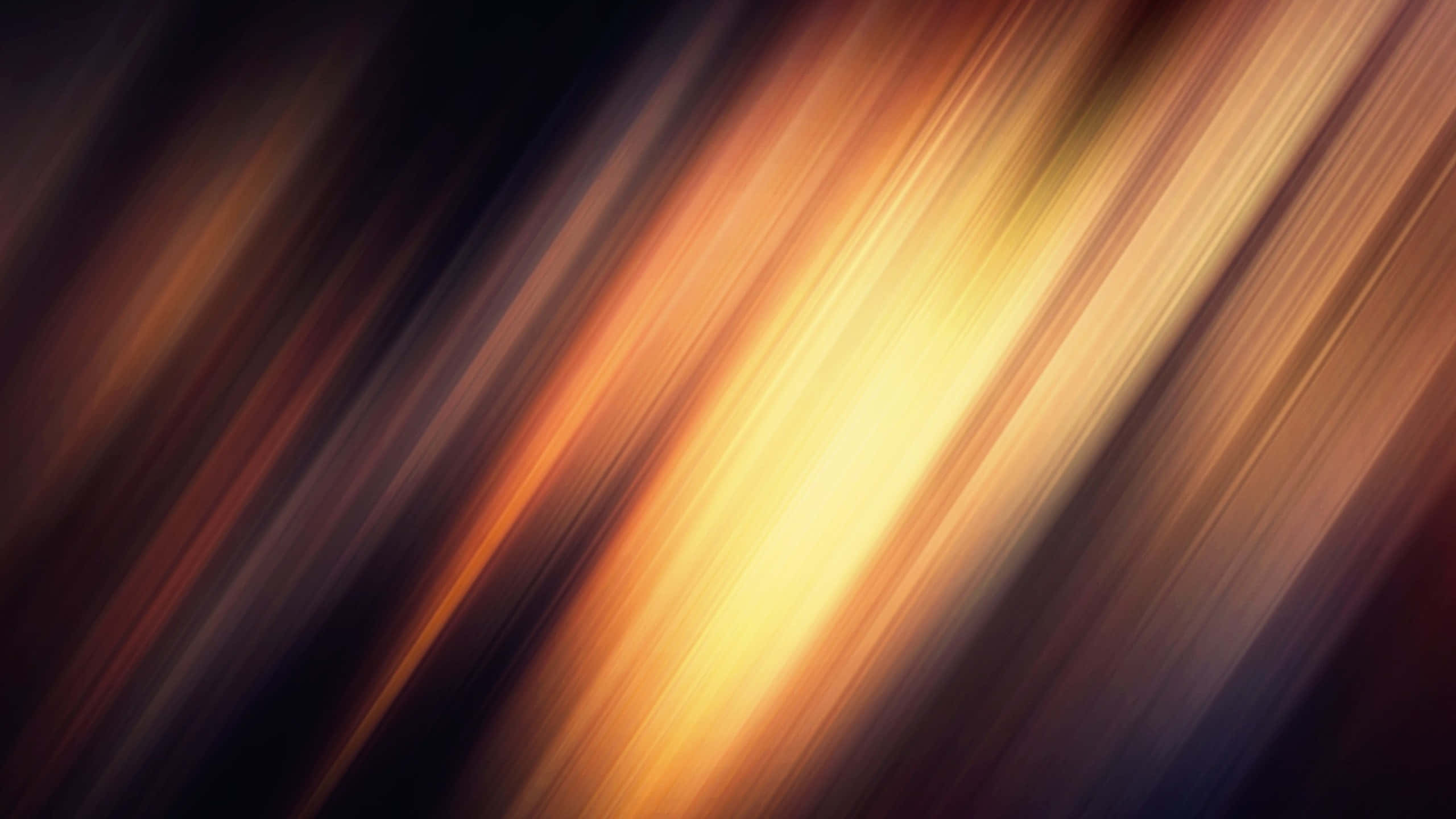 Blur 桌布 壁紙 — 溫暖金色琥珀色光的動態對角線條紋在深邃陰暗的背景上模糊。