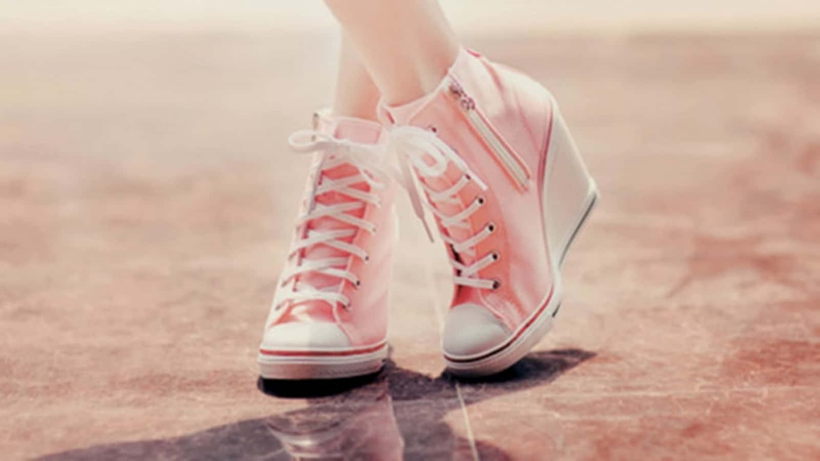 Pink Shoes 桌布 壁紙 — 溫暖陽光下，粉紅色高筒楔形運動鞋搭配白色鞋帶，特寫於反光的粉紅色路面上。