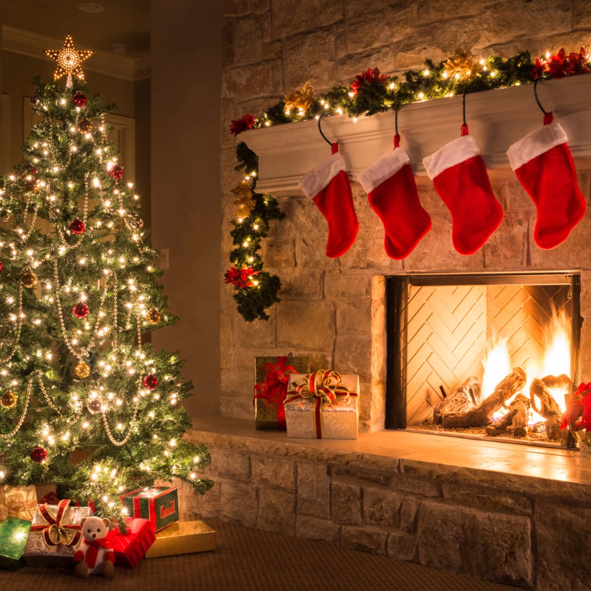 Teams Christmas 桌布 壁紙 — 溫馨的聖誕場景，有亮燈的聖誕樹和裝飾著襪子和禮物的壁爐。