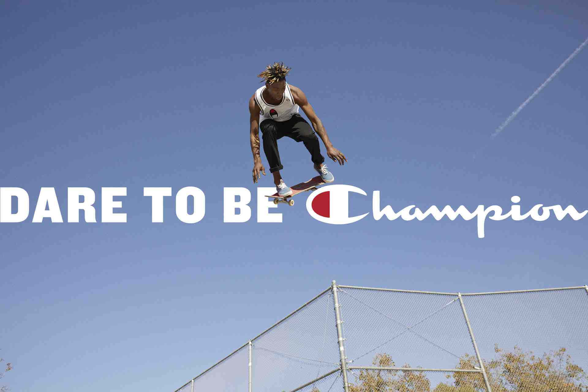 Champion 桌布 壁紙 — 滑板手在半空中，背景是清澈的藍天，下方有圍欄，並覆蓋 'DARE TO BE Champion' 文字。