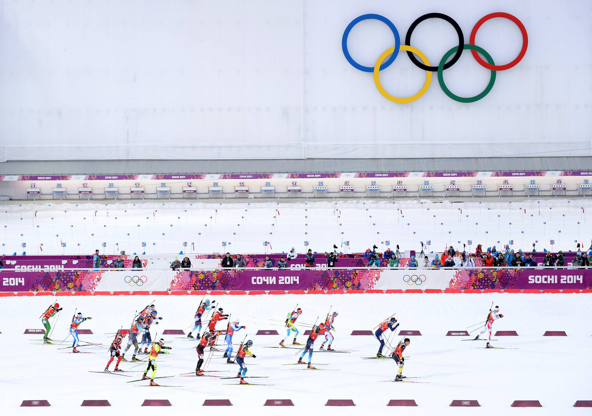 Winter Olympics 桌布 壁紙 — 滑雪運動員在索契2014年冬奧會的五環標誌下，在雪地上競速。