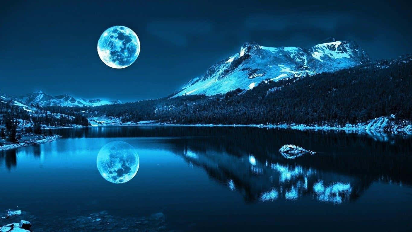 月光 桌布 壁紙 — 滿月在積雪的山峰上發光，完美地倒映在夜晚寧靜的藍色湖泊中。
