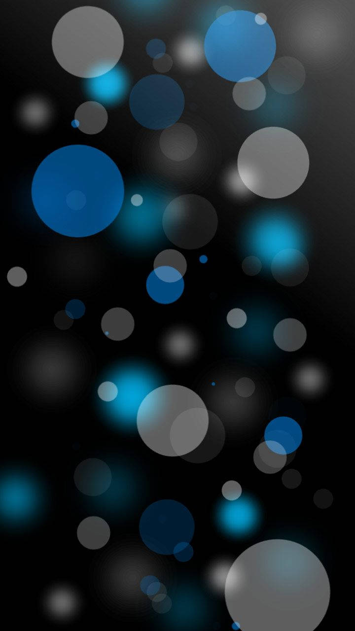 三星 桌布 壁紙 — 漂浮的藍色和灰色圓圈在深黑色背景上柔和發光，營造出夢幻般的抽象散景效果。