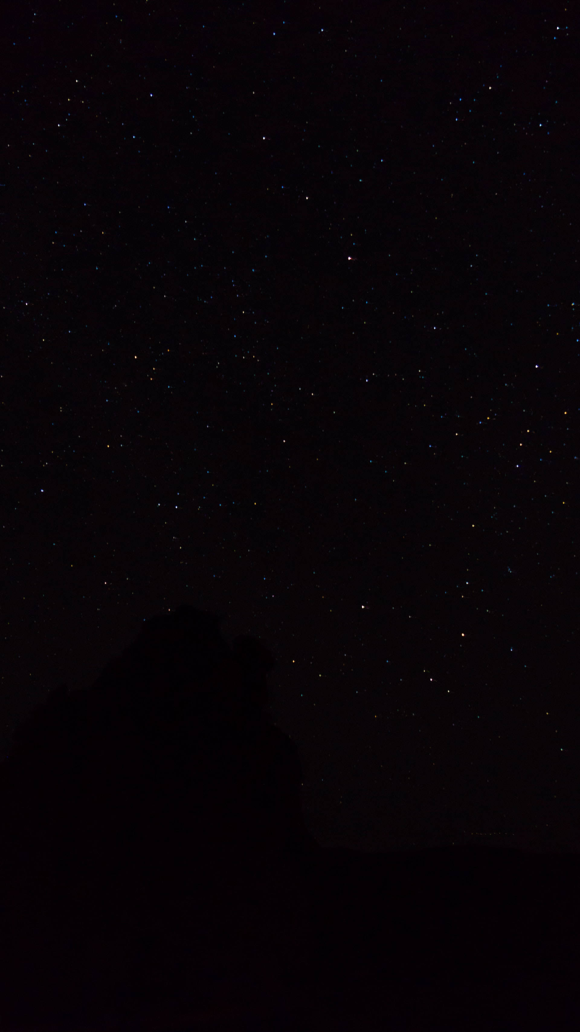 Starry 桌布 壁紙 — 漆黑的夜空下，無數閃爍的星星點綴在黑暗的山脈輪廓之上。