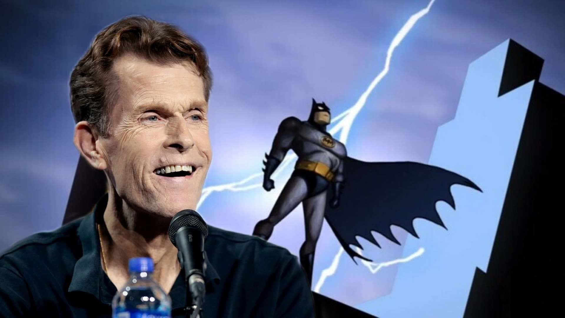Kevin Conroy 桌布 壁紙 — 演員Kevin Conroy在閃電風暴背景前，於風格化的蝙蝠俠剪影旁對著麥克風微笑。