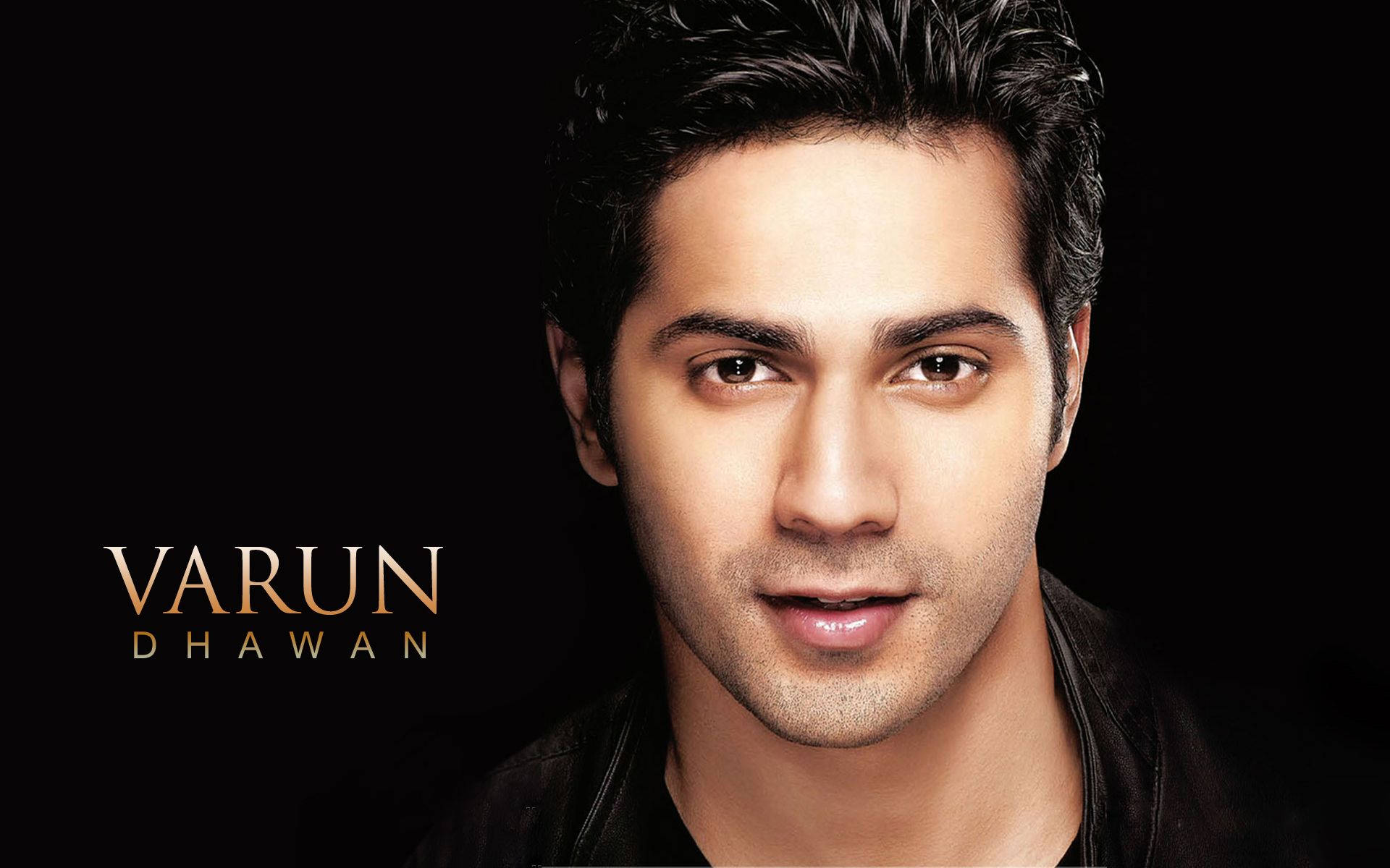 Varun 桌布 壁紙 — 演員Varun Dhawan的close-up肖像，黑色背景上帶有金色文字疊加。