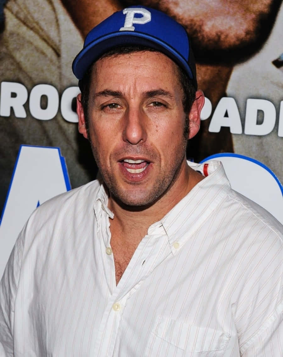 Adam Sandler 桌布 壁紙 — 演員亞當·山德勒在宣傳活動中戴著一頂帶有白色「P」的藍色帽子，穿著白色鈕扣襯衫。