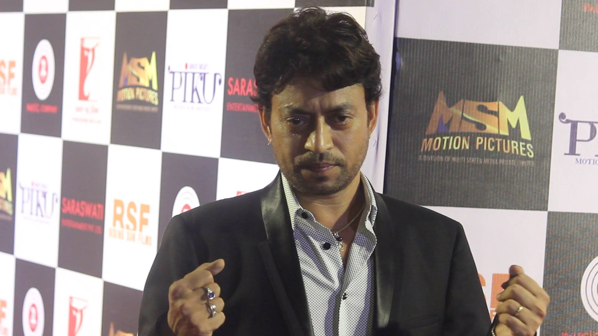 Irrfan Khan 桌布 壁紙 — 演員伊凡卡漢在一個品牌格子背景的新聞發布會上熱情地做手勢。