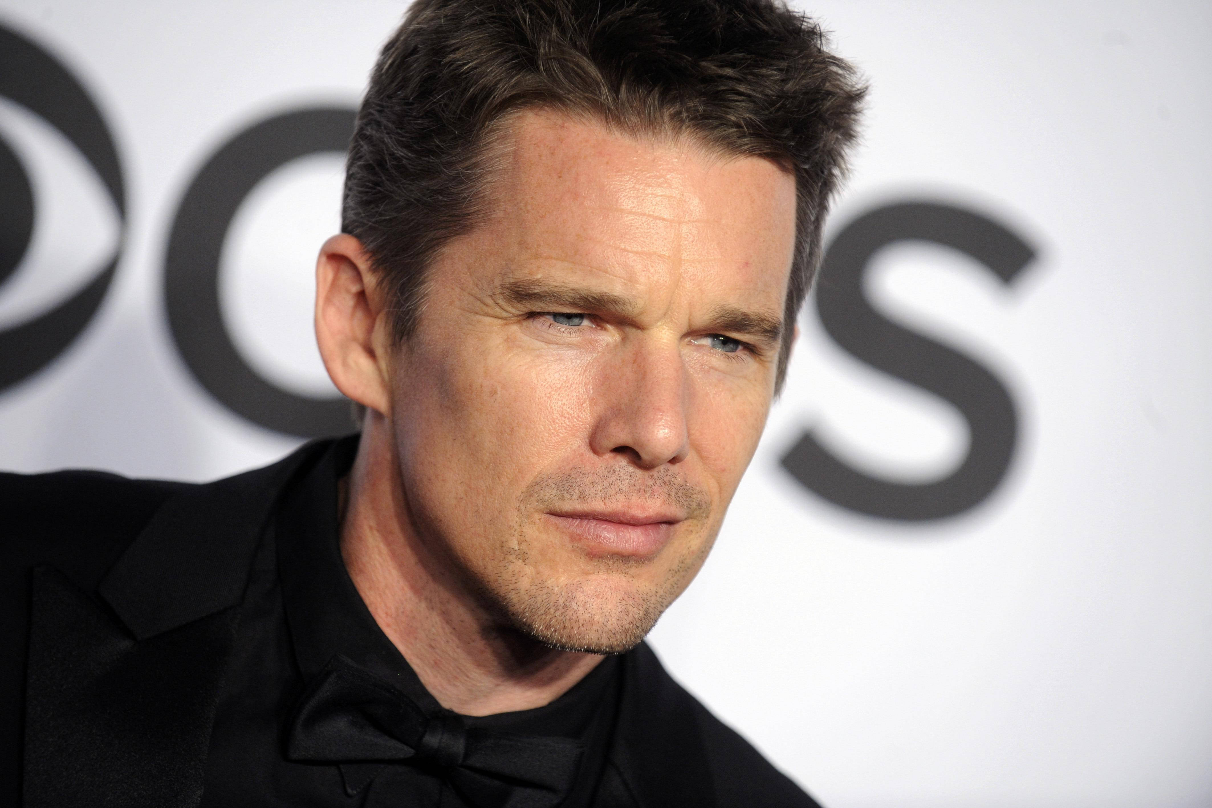 Celebrity 桌布 壁紙 — 演員伊森·霍克的近距離肖像，身穿黑色燕尾服，背景是模糊的CBS標誌。