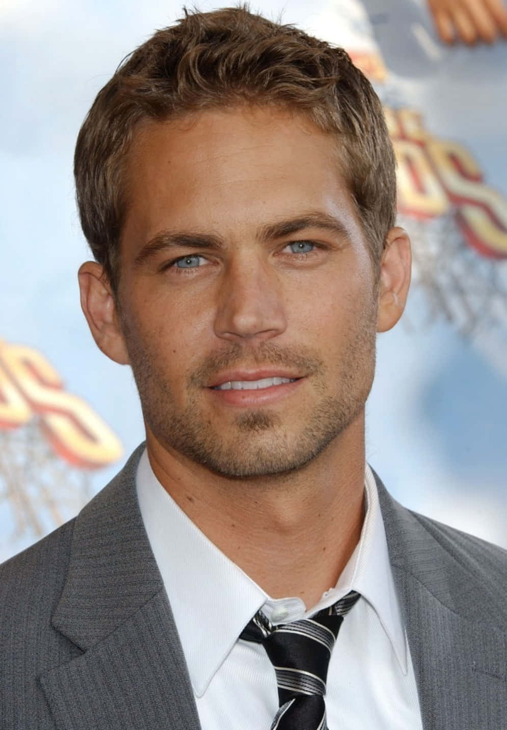 Paul Walker 桌布 壁紙 — 演員保羅·沃克在宣傳活動中的特寫肖像，身穿灰色西裝和條紋領帶。