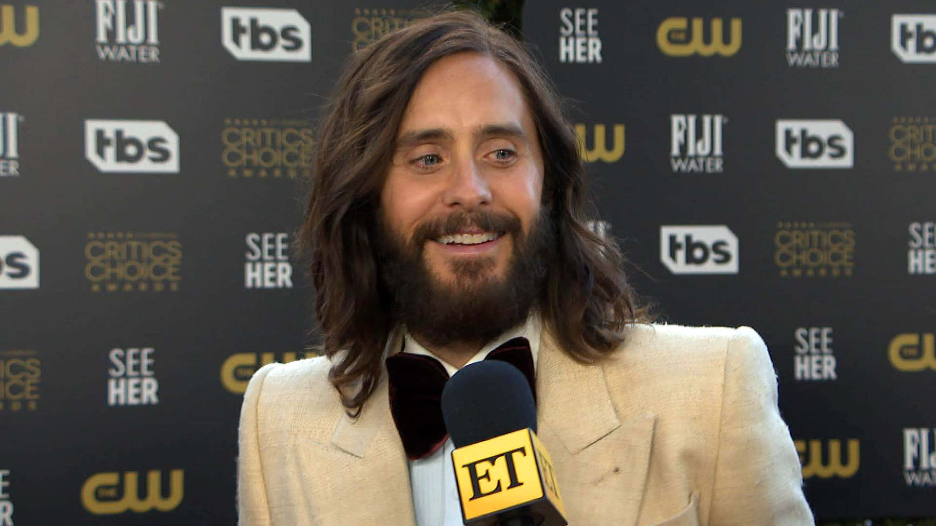 jared leto 桌布 壁紙 — 演員傑瑞德·雷托在 Critics Choice Awards 紅地毯上對著 ET 麥克風溫暖微笑說話。