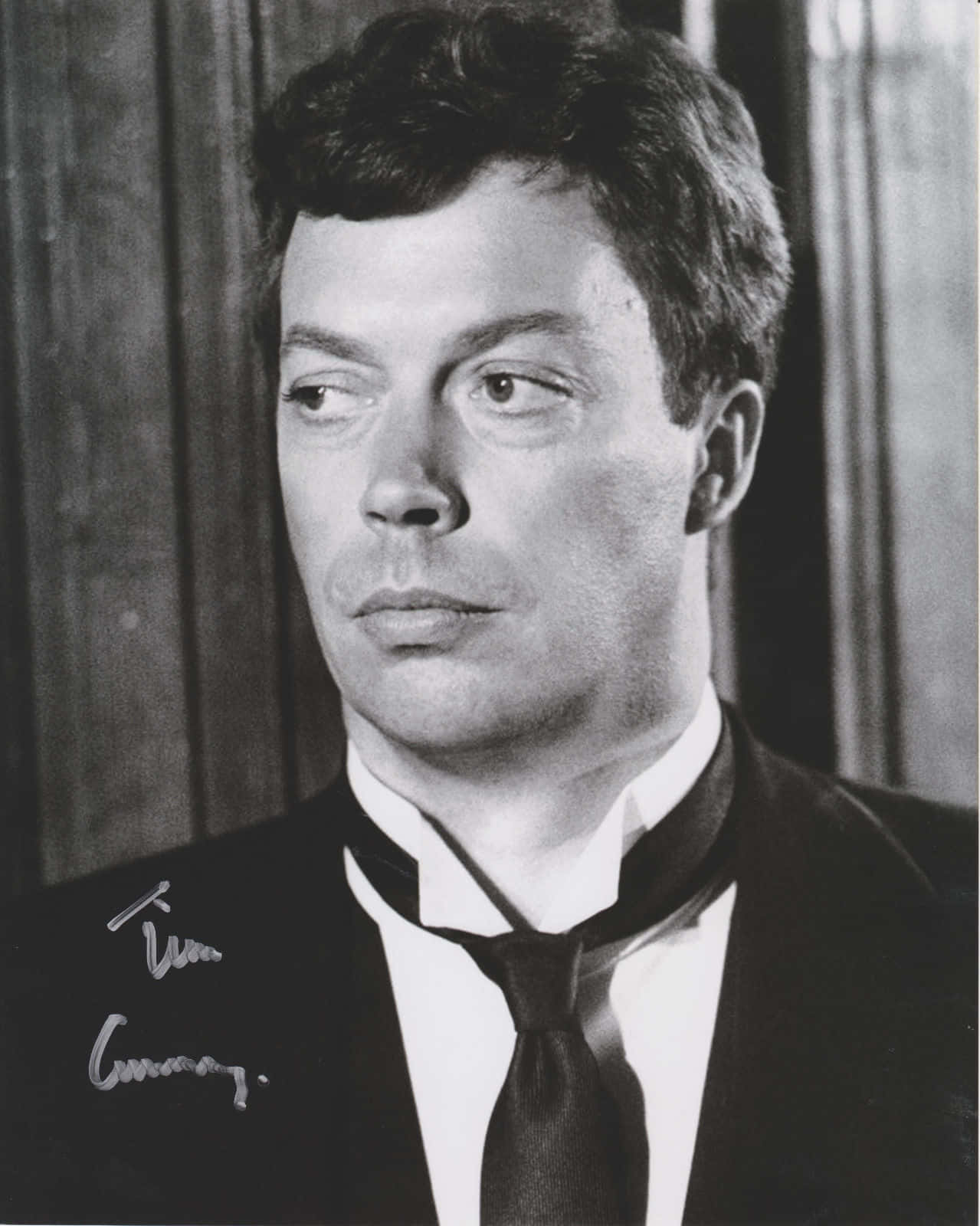Tim Curry 桌布 壁紙 — 演員提姆·柯瑞穿著西裝、表情嚴肅地望向一旁的黑白肖像。