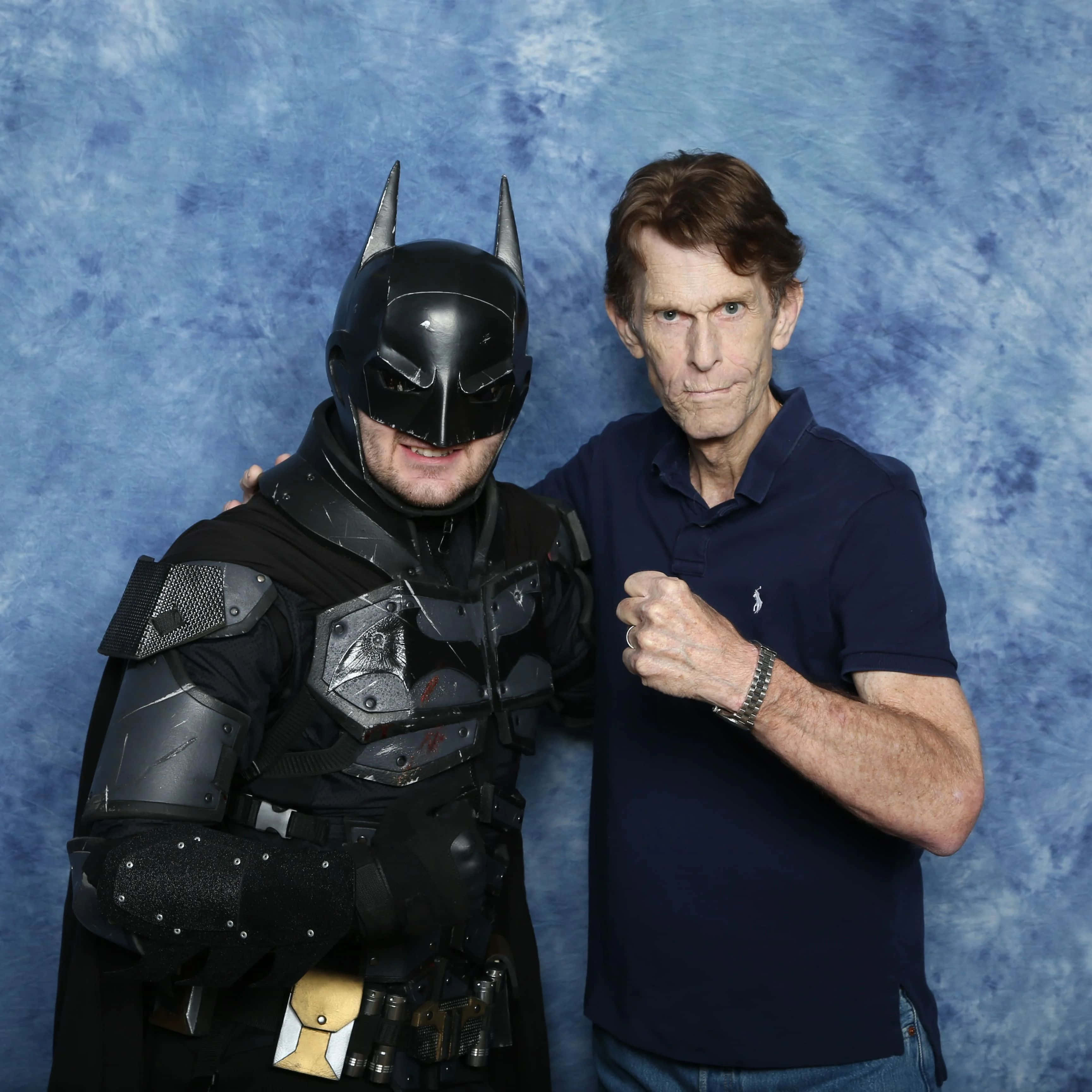 Kevin Conroy 桌布 壁紙 — 演員班艾佛列克在攝影棚內，以帶有紋理的藍色背景襯托，與蝙蝠俠服裝一同擺姿勢。