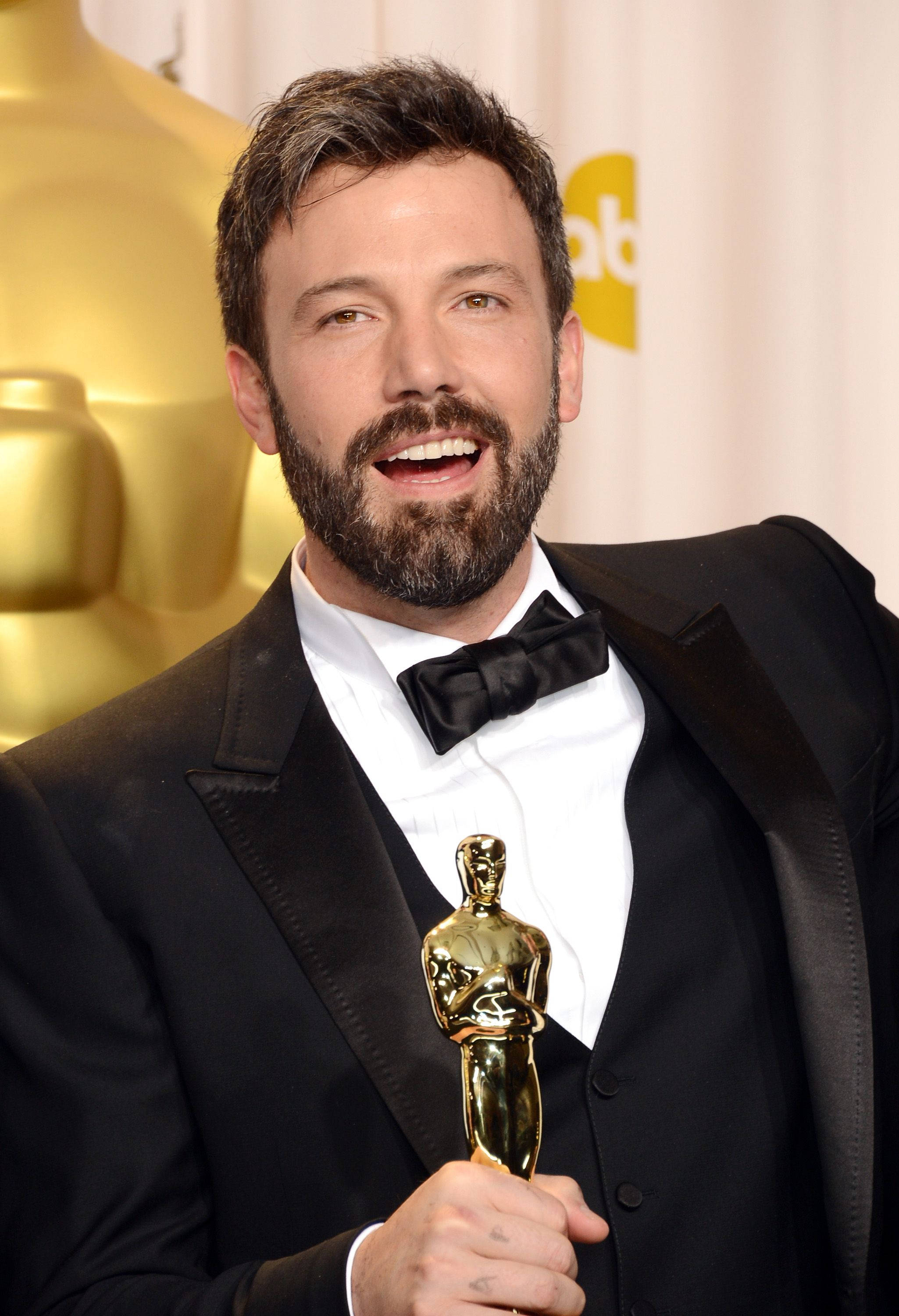 Ben Affleck 桌布 壁紙 — 演員班艾佛列克身穿燕尾服，自豪地手持金色奧斯卡獎座，在華麗的頒獎典禮上綻放光芒。