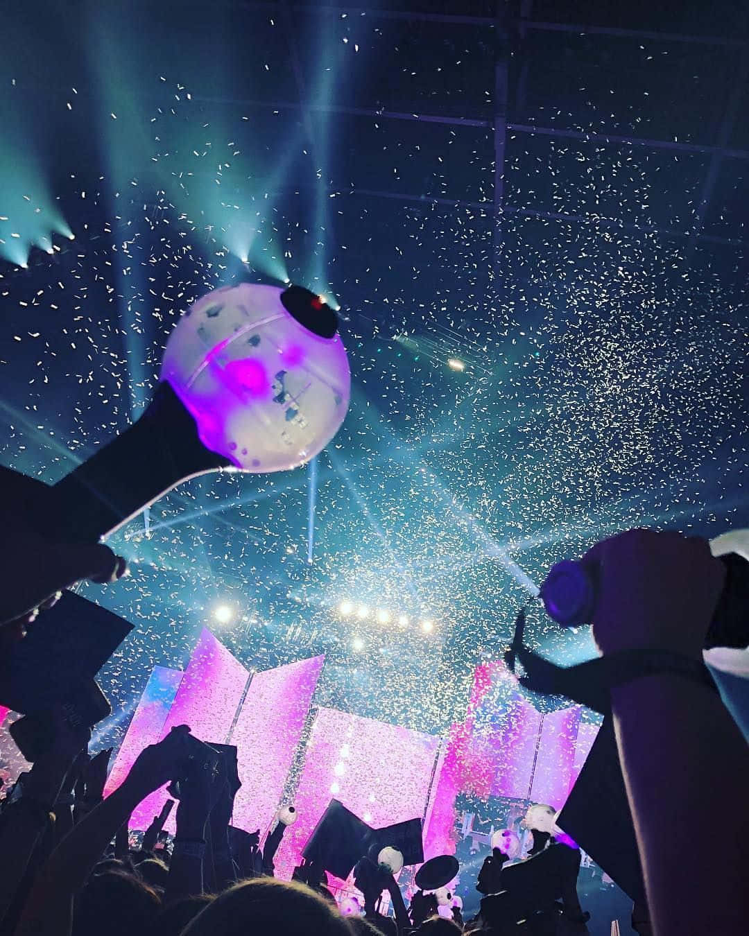 Bts Army Bomb 桌布 壁紙 — 演唱會上的人群在充滿活力的藍色和粉紅色舞台燈光下，舉著發光的螢光棒，五彩紙屑如雨般落下。