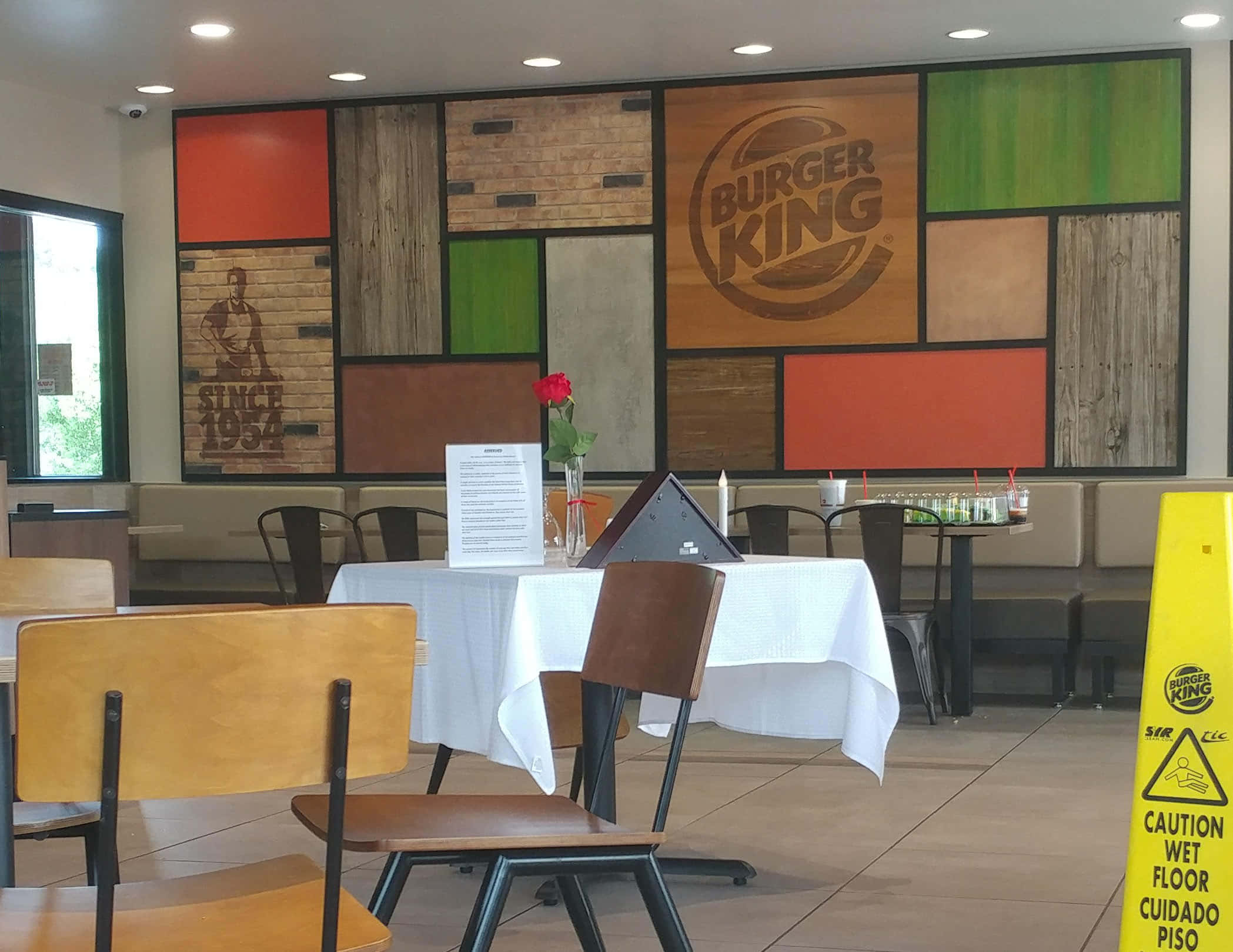 Burger King 桌布 壁紙 — 漢堡王餐廳內部，設有木質鑲板牆壁、白色桌布和黃色濕地標誌。