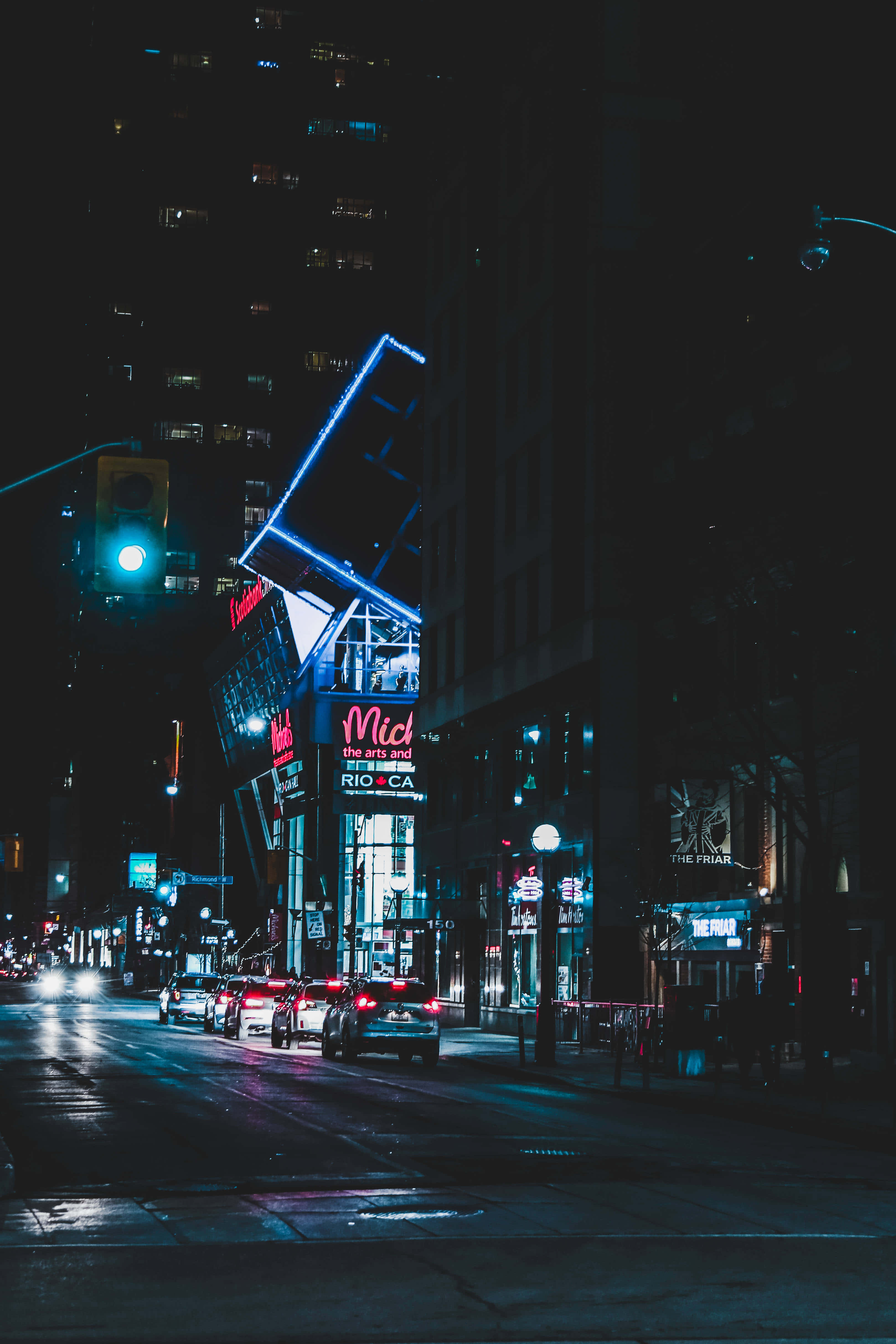Neon City Aesthetic 桌布 壁紙 — 潮濕的城市街道在夜晚閃爍著來自高聳建築物和來往汽車的霓虹燈光。