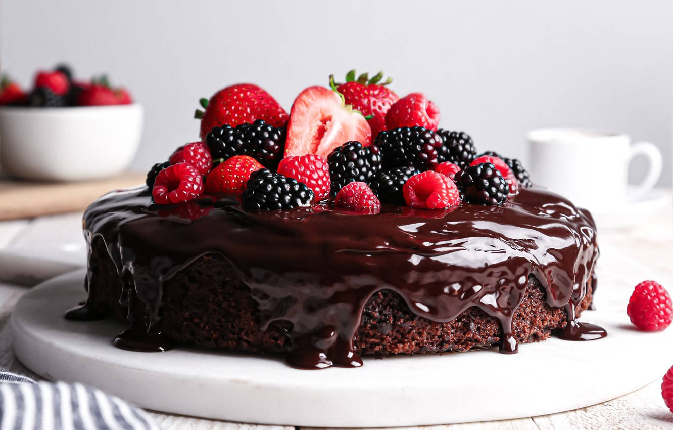 Birthday Cake 桌布 壁紙 — 濃郁巧克力蛋糕，滴落光澤甘納許，上面鋪滿鮮豔的新鮮莓果，放在白色大理石盤上。