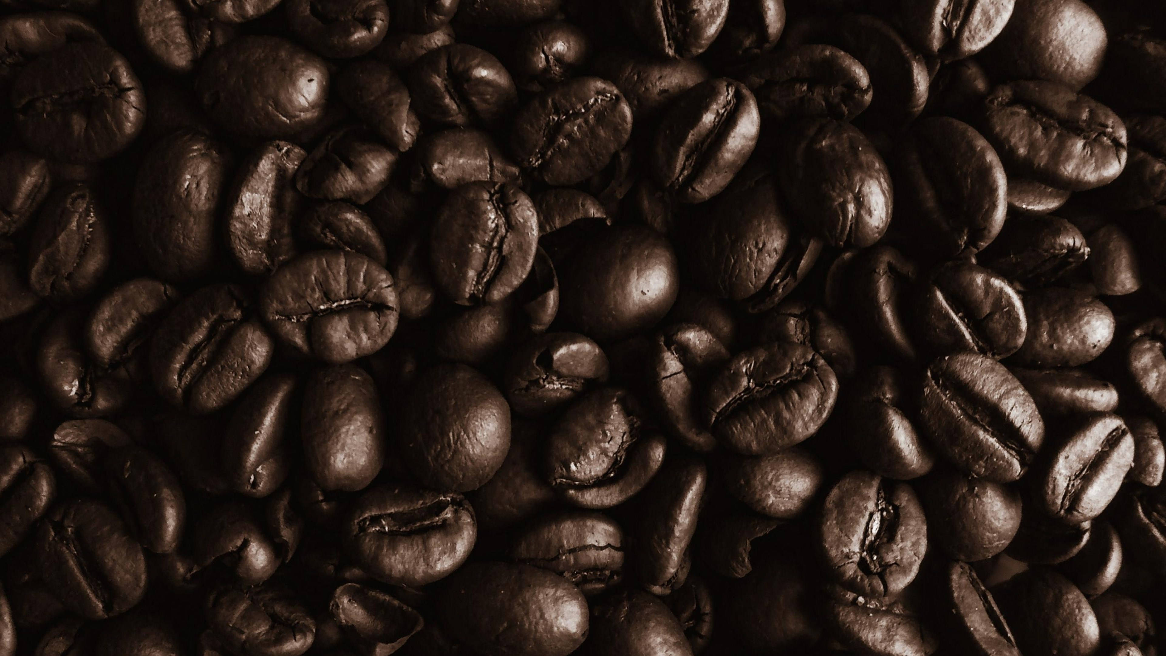 beans 桌布 壁紙 — 濃郁深烘焙咖啡豆的特寫，具有光澤質感和深棕色調。