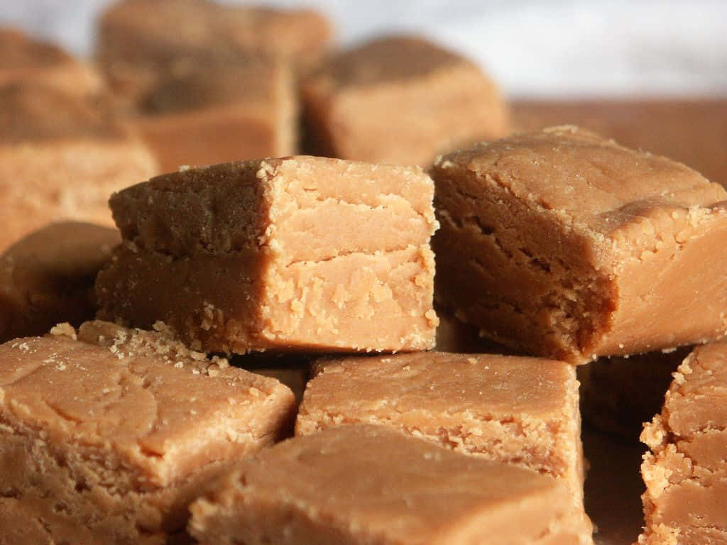 Penuche Fudge 桌布 壁紙 — 濃郁焦糖色軟糖方塊的特寫，表面有紋理，光線柔和。