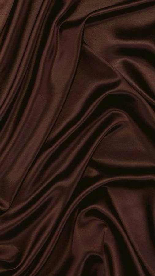 Dark Brown Aesthetic 桌布 壁紙 — 濃郁的巧克力棕色緞面布料，帶有深邃皺褶和捕捉柔和光線的光澤亮點。