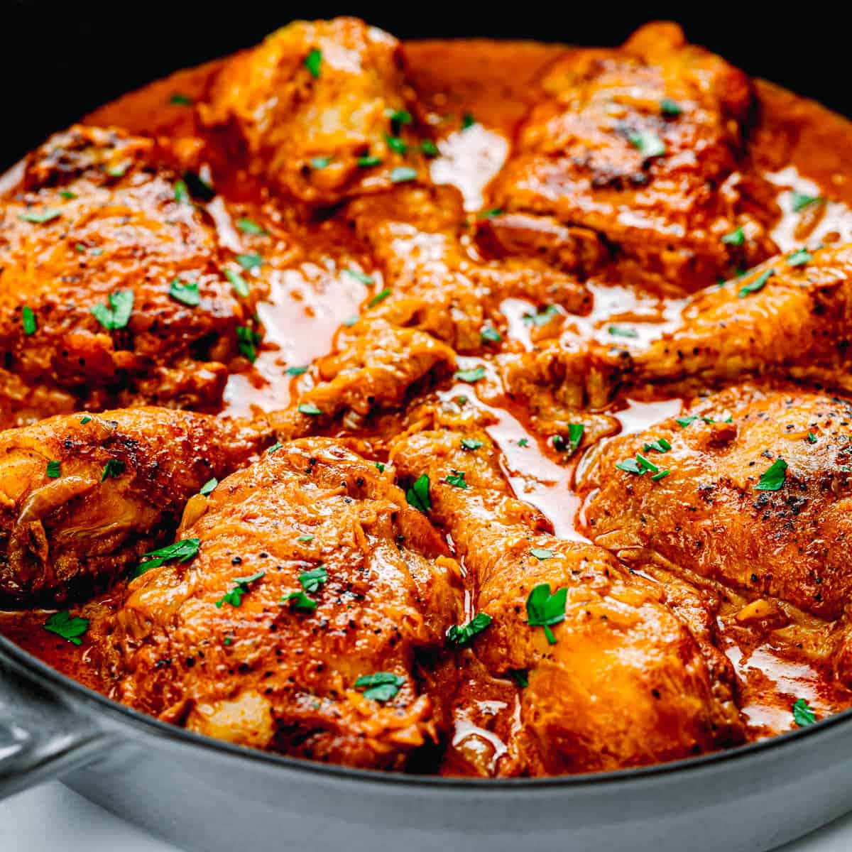 Chicken 桌布 壁紙 — 濃郁香料雞塊在光澤醬汁中慢煮，飾以新鮮歐芹，置於深色煎鍋中。