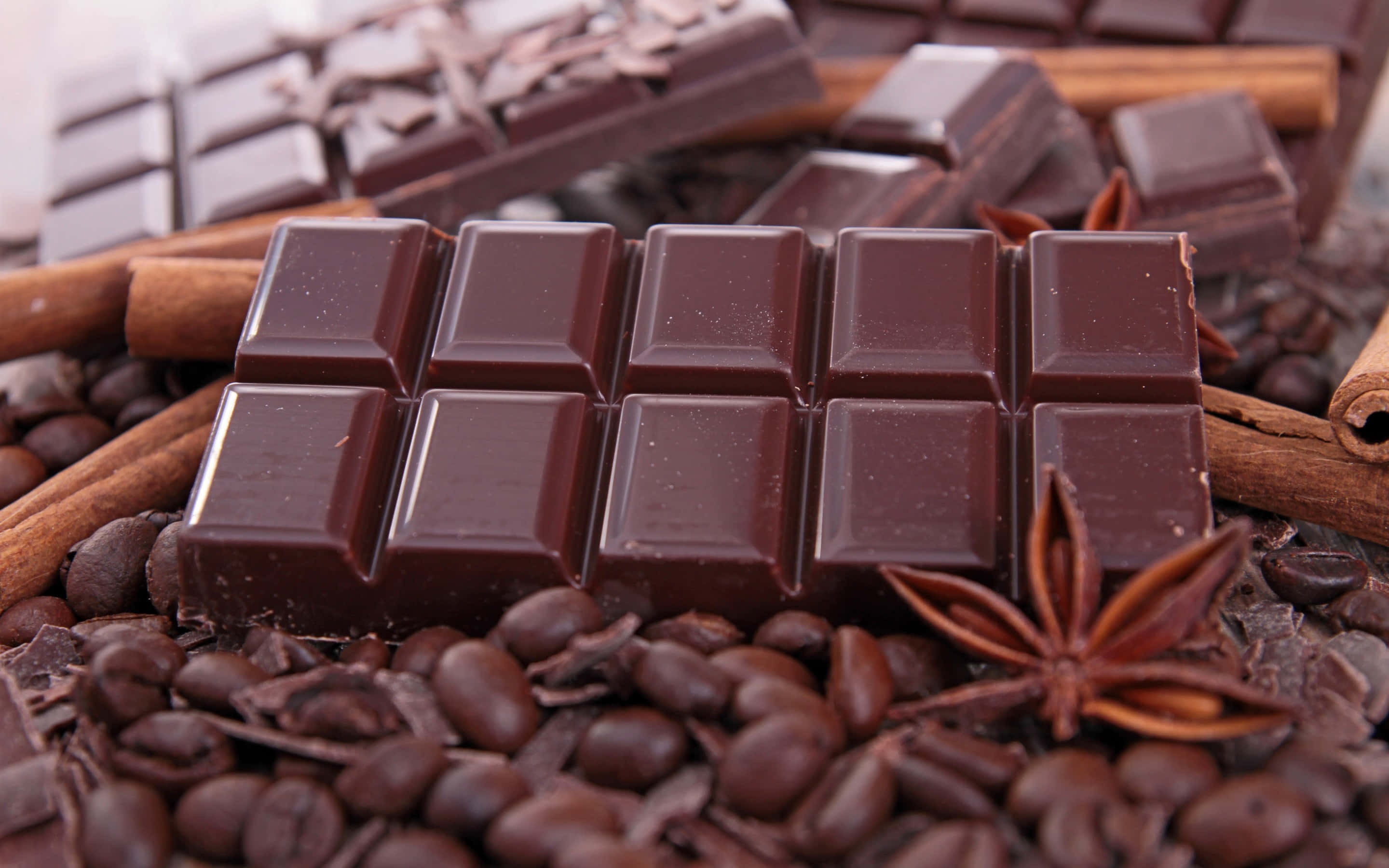 Dark Chocolate 桌布 壁紙 — 濃郁黑巧克力條 nestled 在咖啡豆、肉桂棒和八角之中，呈現奢華的特寫。