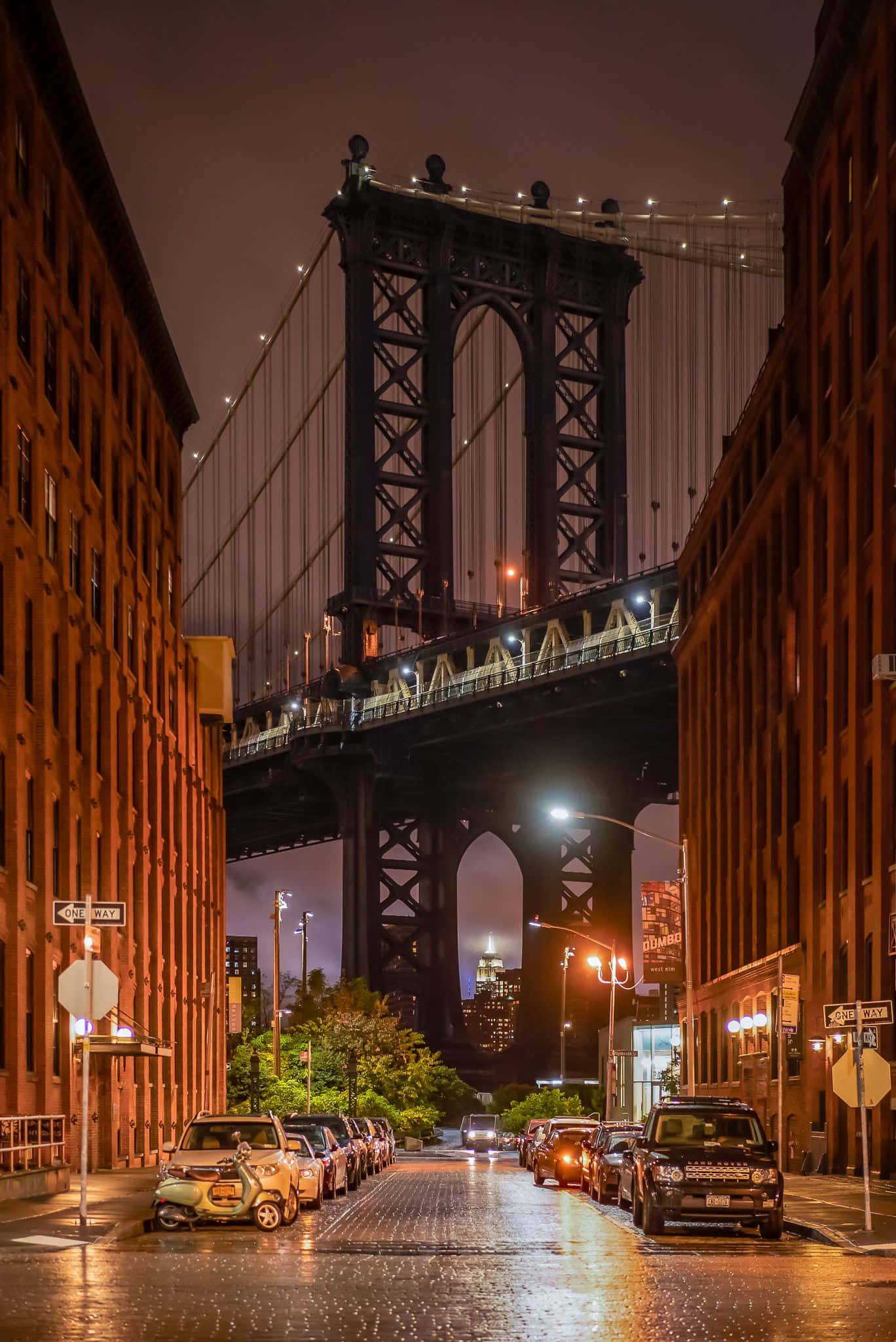 bridge 桌布 壁紙 — 濕漉漉的夜晚城市街道框住了宏偉的曼哈頓大橋，其鋼結構在街燈下閃閃發光，鵝卵石路上停滿了汽車。