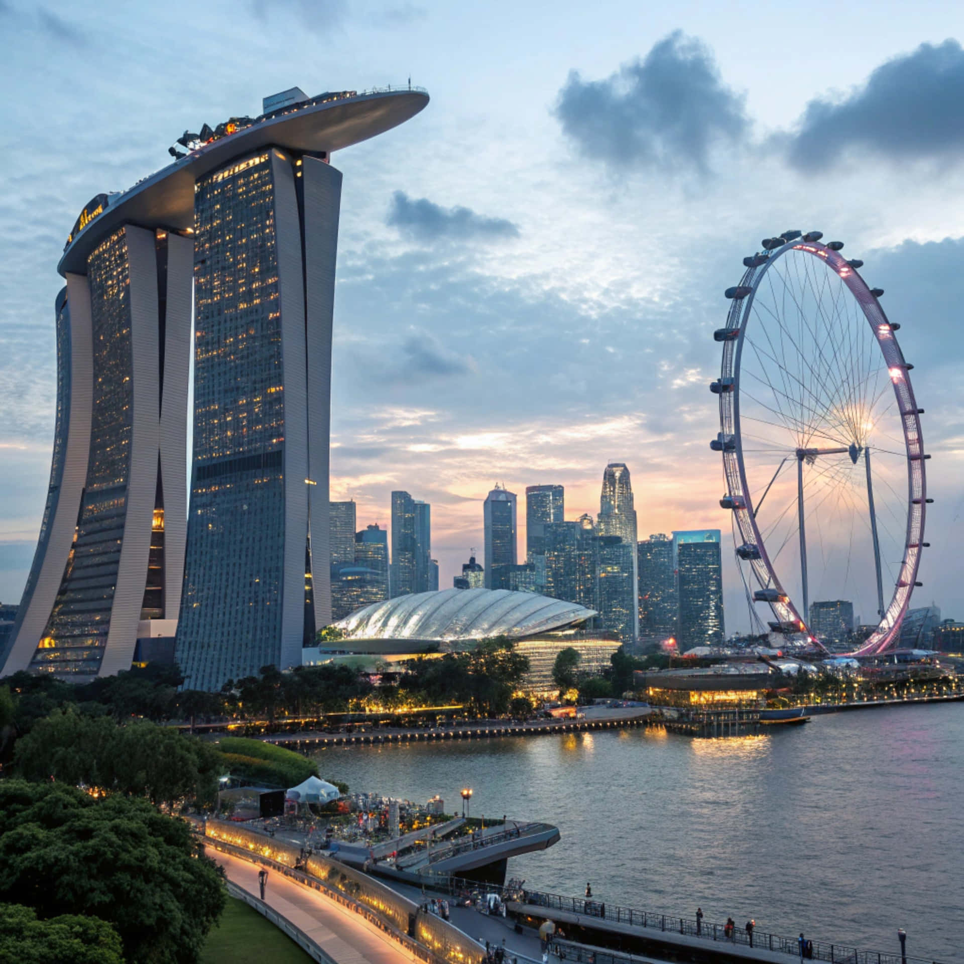 Singapore Skyline 壁紙 — 濱海灣金沙和新加坡摩天觀景輪在暮色天空下閃耀，城市燈光倒映在水面上。