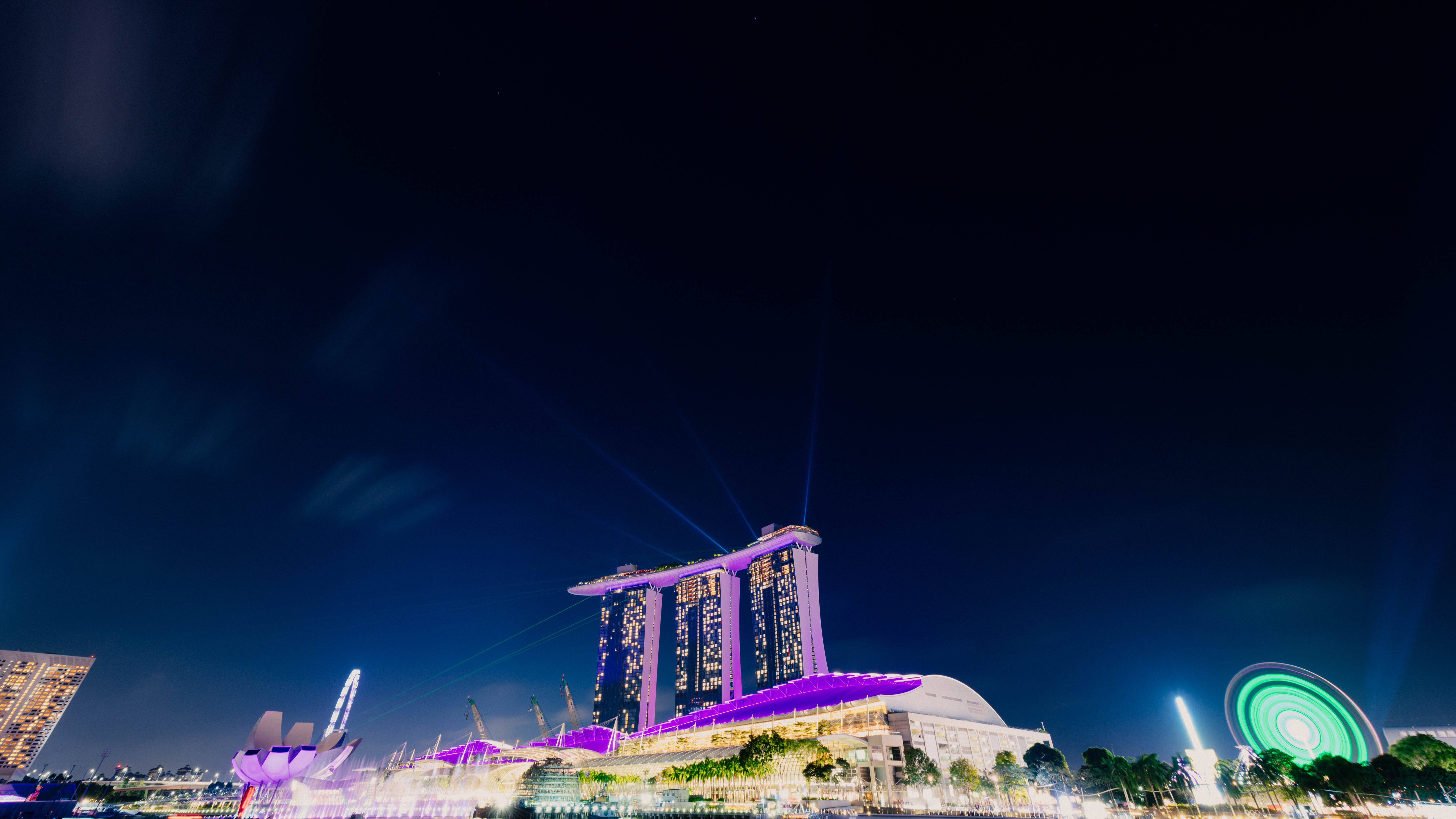 Singapore 桌布 壁紙 — 濱海灣金沙酒店塔樓在深邃的夜空中以紫色燈光璀璨奪目，雷射光束向上射擊。