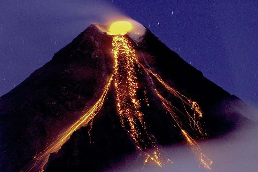 Volcano 桌布 壁紙 — 火山在夜間爆發，發光的熔岩沿著黑暗的山坡流下，星空下。