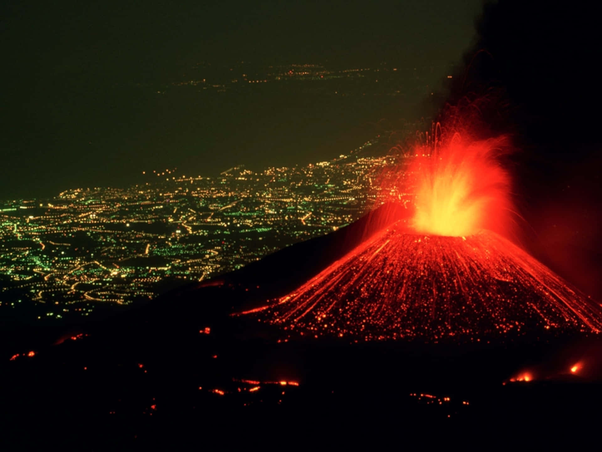 夜間火山爆發，熔岩發光，下方城市燈光 — 夏威夷 壁紙