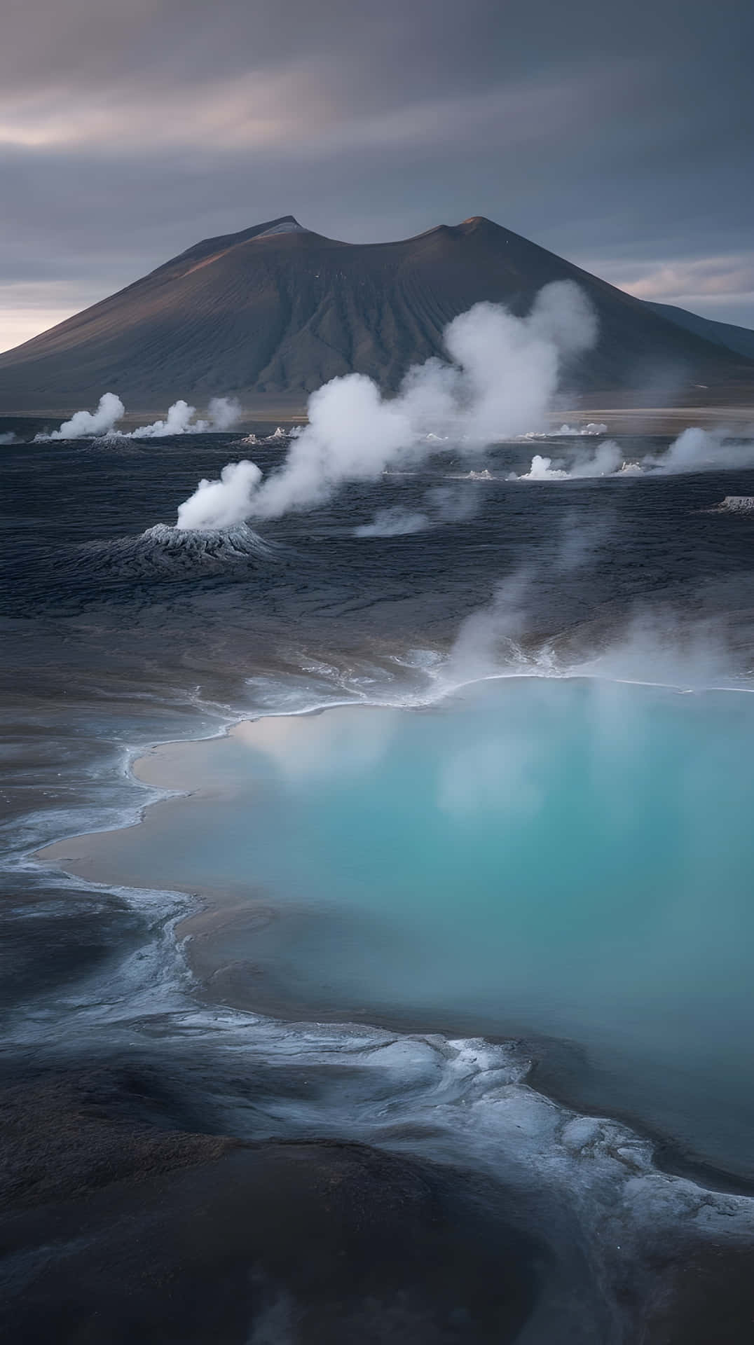 Surreal Volcanic Landscape with Turquoise Steaming Lake at Twilight 壁紙 — 火山景觀，有冒煙的地熱池和一座大山，天空多雲。