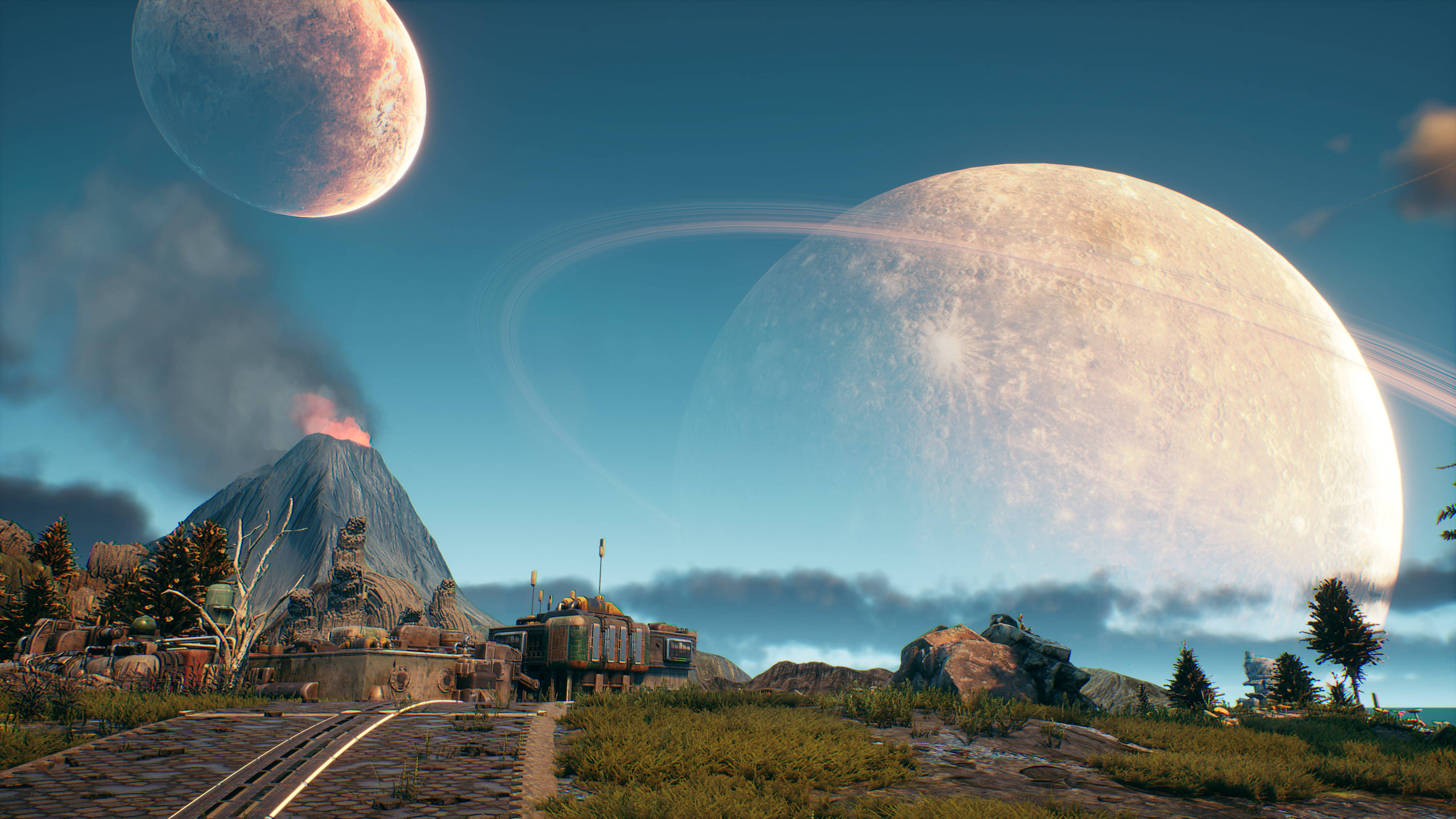 Outer Worlds 桌布 壁紙 — 火山景觀，藍天下有兩顆巨大行星，其中一顆帶有光環，主宰地平線。