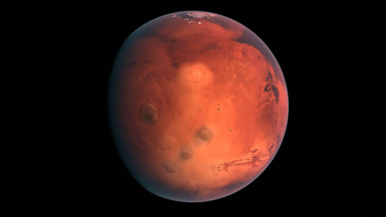 火星 桌布 壁紙 — 火星在黑色太空虛空中發出紅橙色光芒的生動景象，可見隕石坑和極冠。