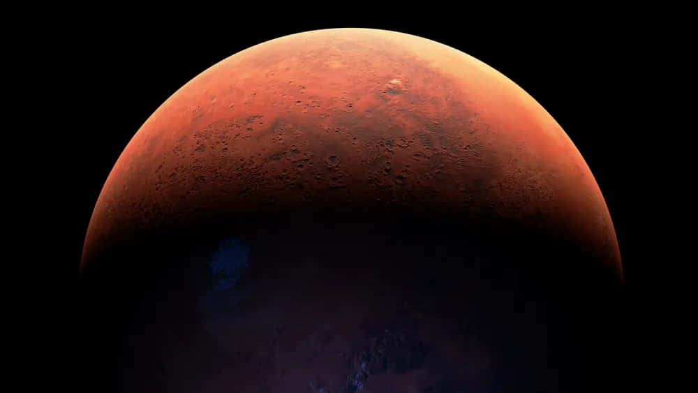 Mars Planet 桌布 壁紙 — 火星的戲劇性特寫，在黑色太空虛空中發出深橙色光芒，表面隕石坑清晰可見，並帶有微妙的藍色大氣霧霾。