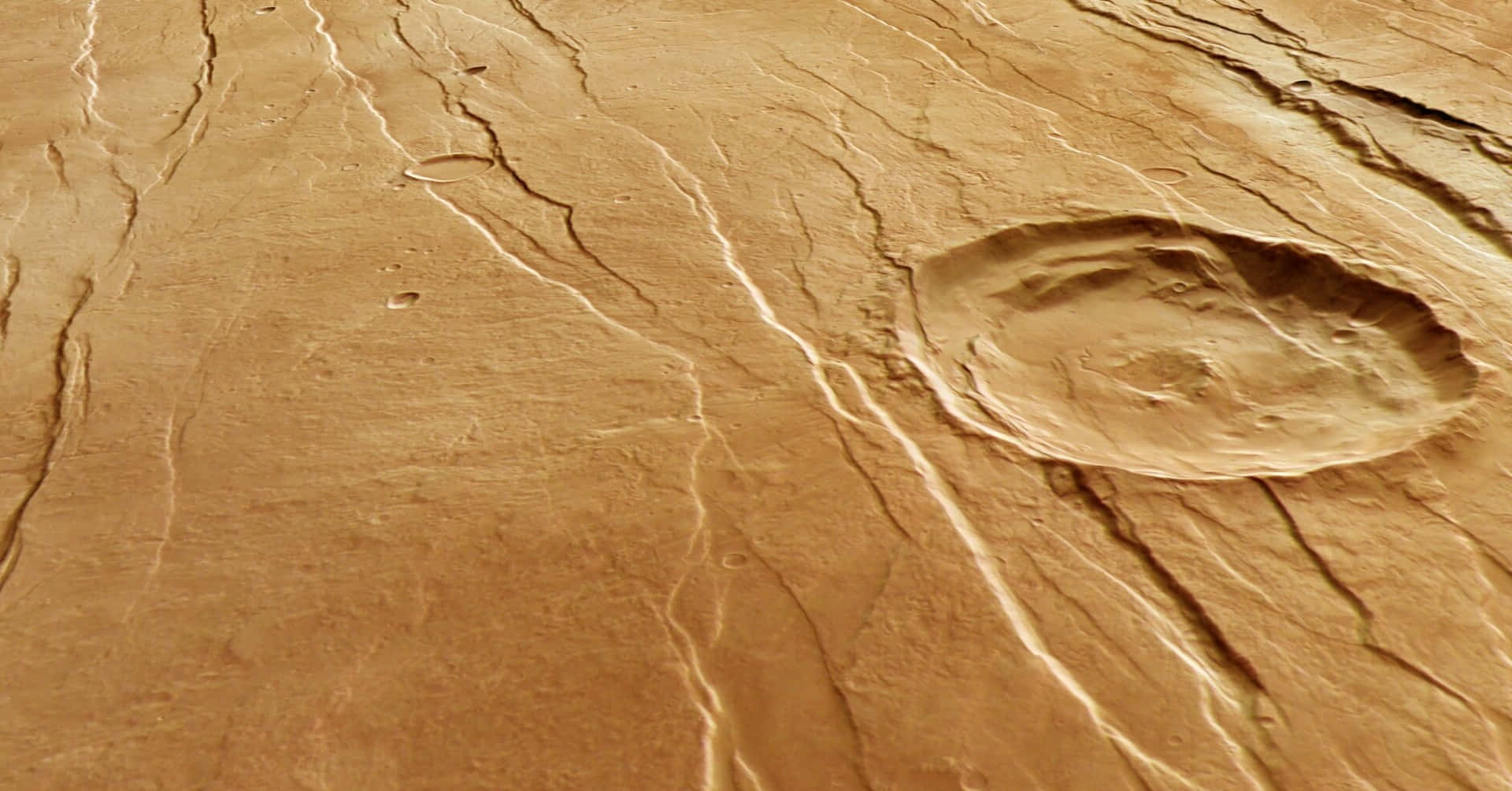 Mars Surface 桌布 壁紙 — 火星表面特寫，顯示裂開的紅褐色土壤和一個帶有細脊的圓形隕石坑。