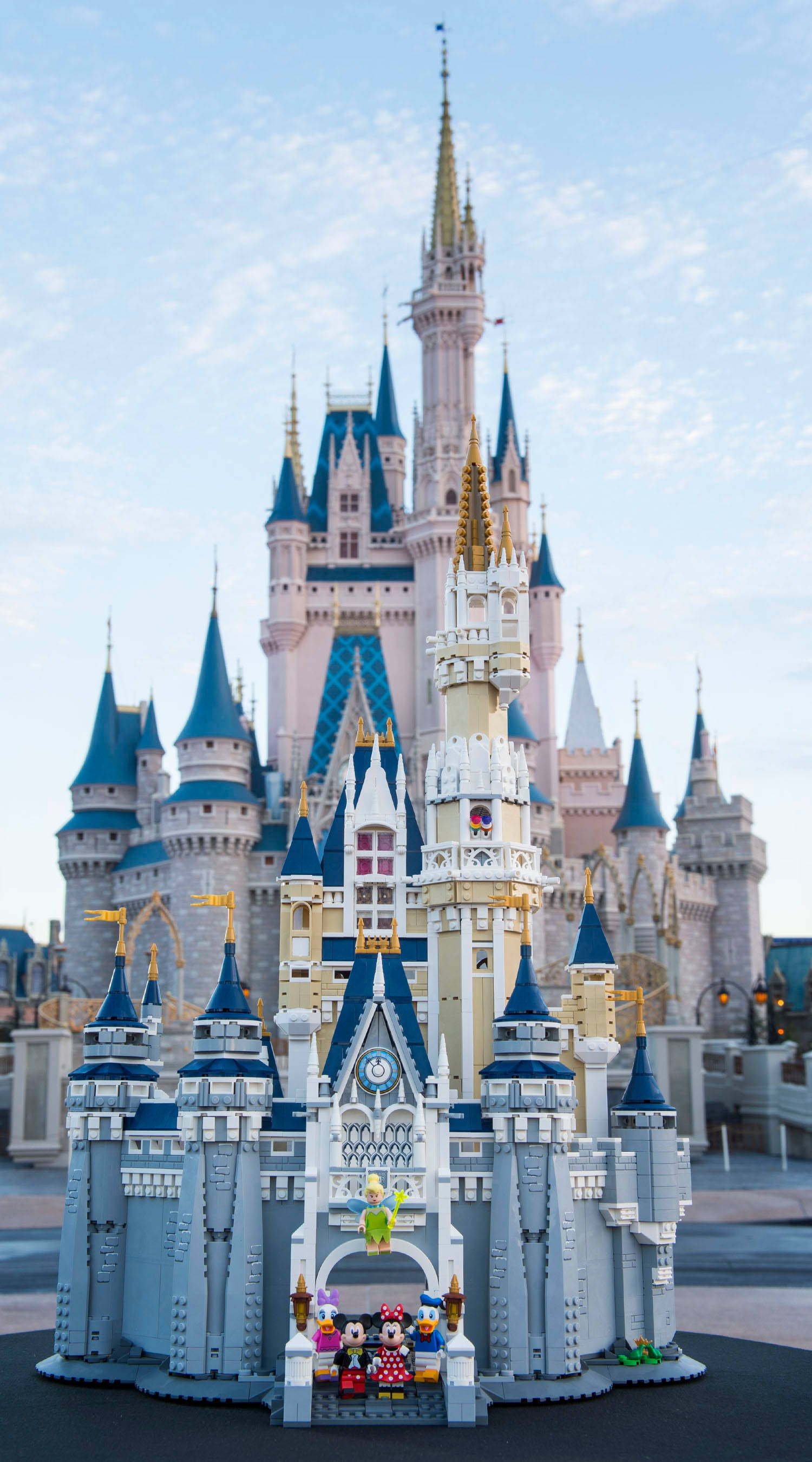 Disney Castle 桌布 壁紙 — 灰姑娘城堡的精細LEGO複製品在明亮的藍天下自豪地矗立在真實城堡前。