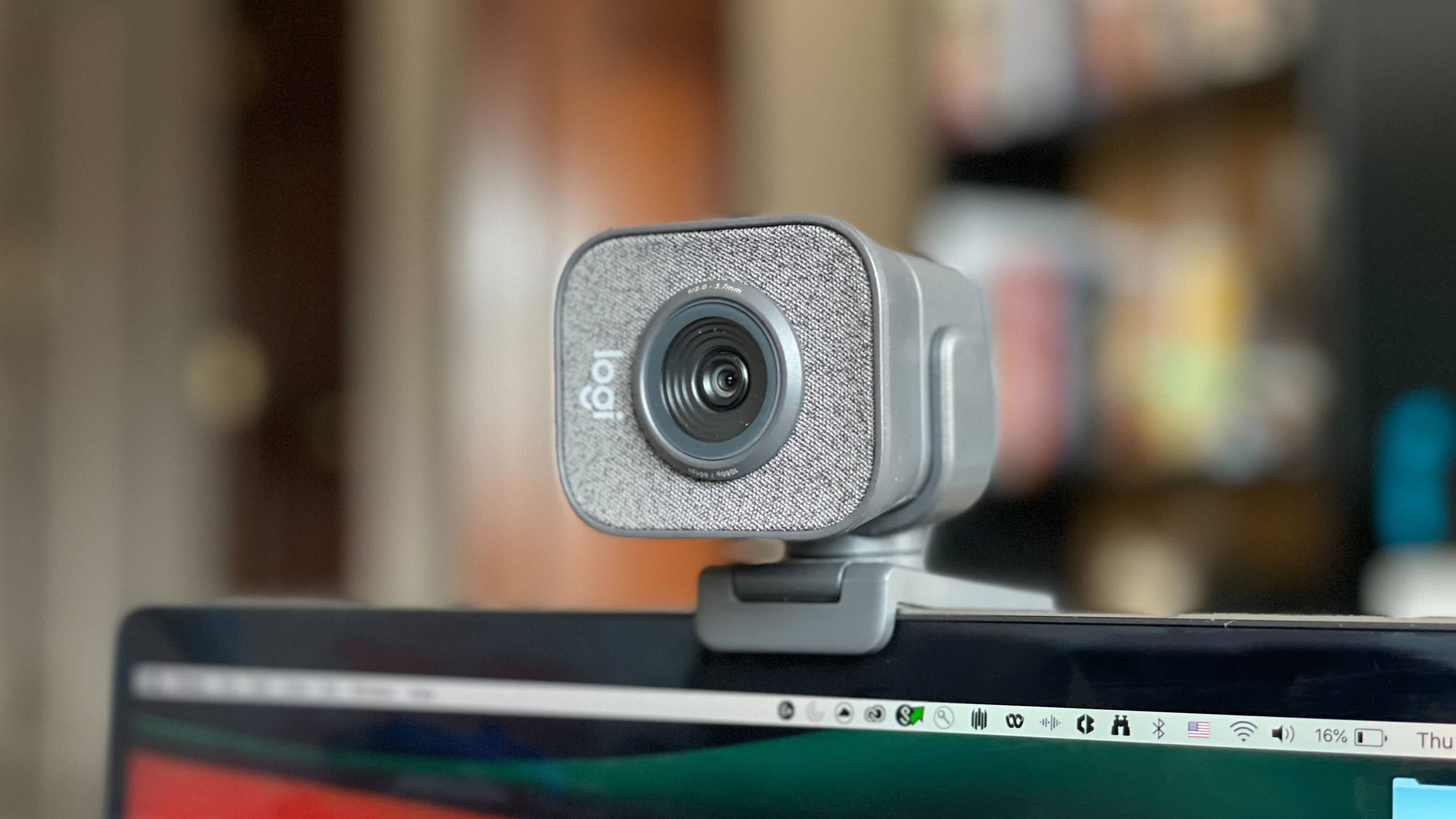 Webcam 桌布 壁紙 — 灰色Logitech網路攝影機的特寫，安裝在筆記型電腦上，背景是模糊的書架。