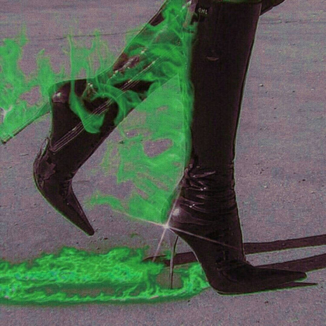 帶有霓虹綠色火焰效果的黑色高跟靴，在人行道上。 — 綠色美學 GIF 壁紙