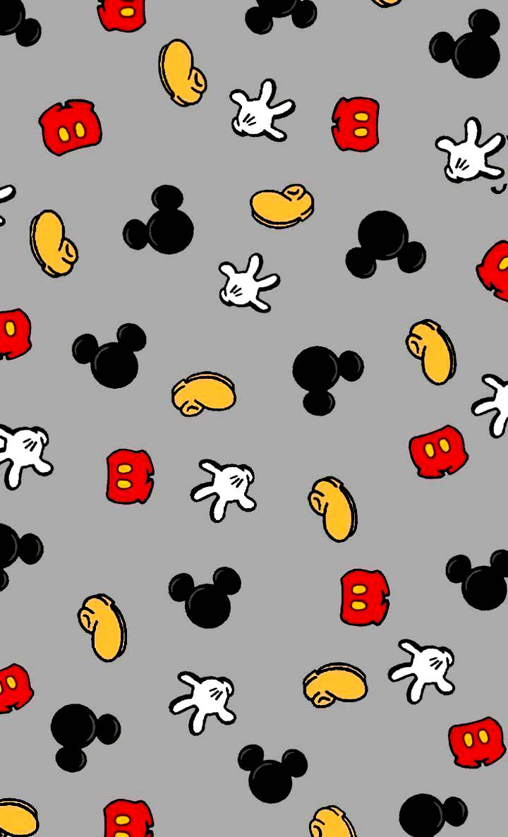 Mickey Mouse Ears 桌布 壁紙 — 灰色壁紙，上面散落著經典紅、黃、黑色的米奇老鼠頭、手套和鞋子圖案。