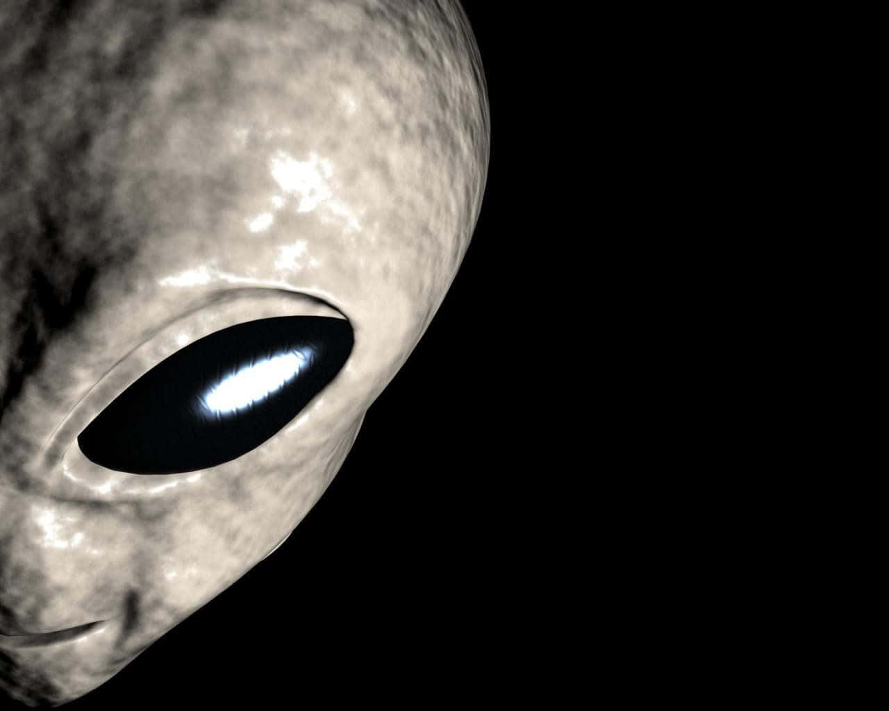外星人 桌布 壁紙 — 灰色外星人面孔特寫，有一隻發光的大眼睛，背景是黑色虛空。