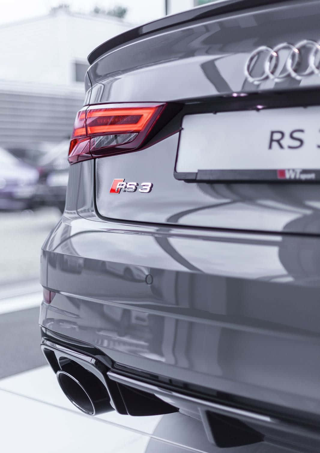 Audi Rs3 桌布 壁紙 — 灰色奧迪RS3轎車的尾部特寫，展現其運動型排氣管和銳利的尾燈。