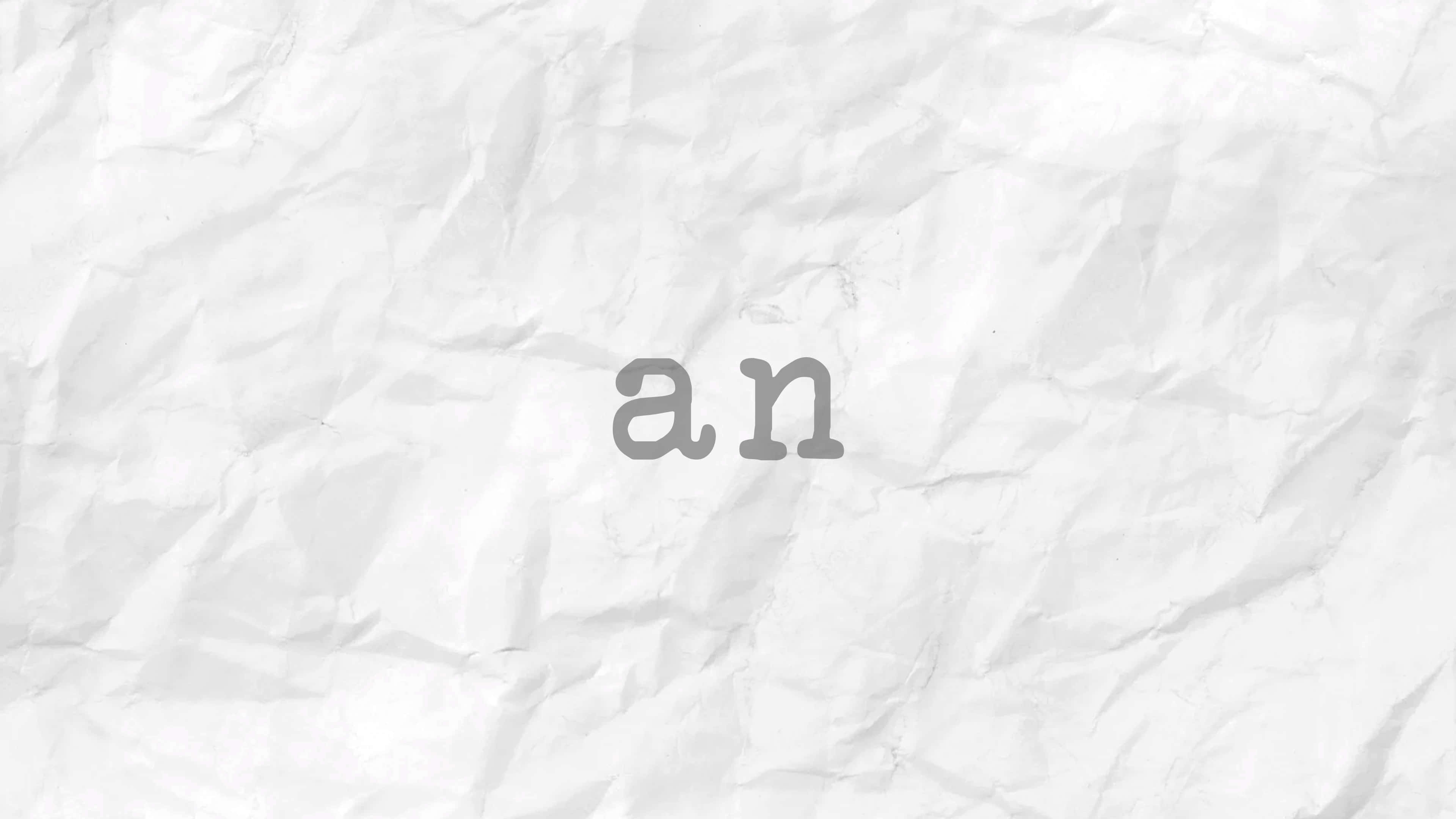 Typography 桌布 壁紙 — 灰色字體的「an」字詞放置在帶有紋理的白色皺紙背景上。